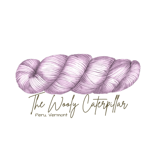 A lavender-colored twisted yarn with gold text reading 'The Wooly Caterpillar' and smaller text 'Peru, Vermont' on a black background.