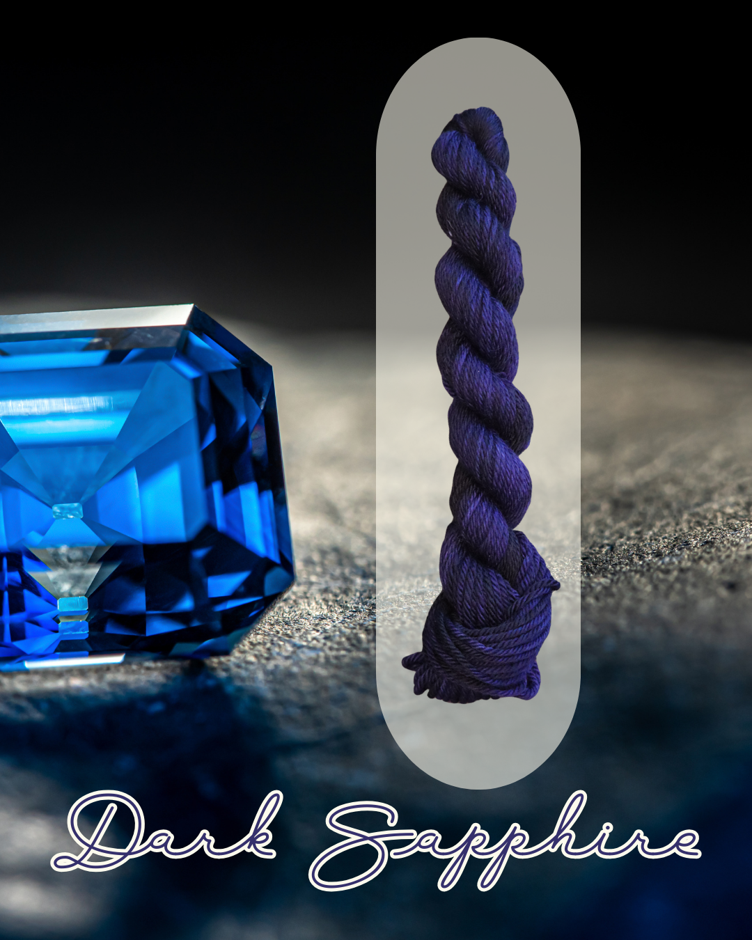 A close-up image of a large, blue, faceted gemstone on a textured dark surface, with a deep blue twisted skein of yarn vertically aligned next to it, and the words "Dark Sapphire" written in cursive font at the bottom.