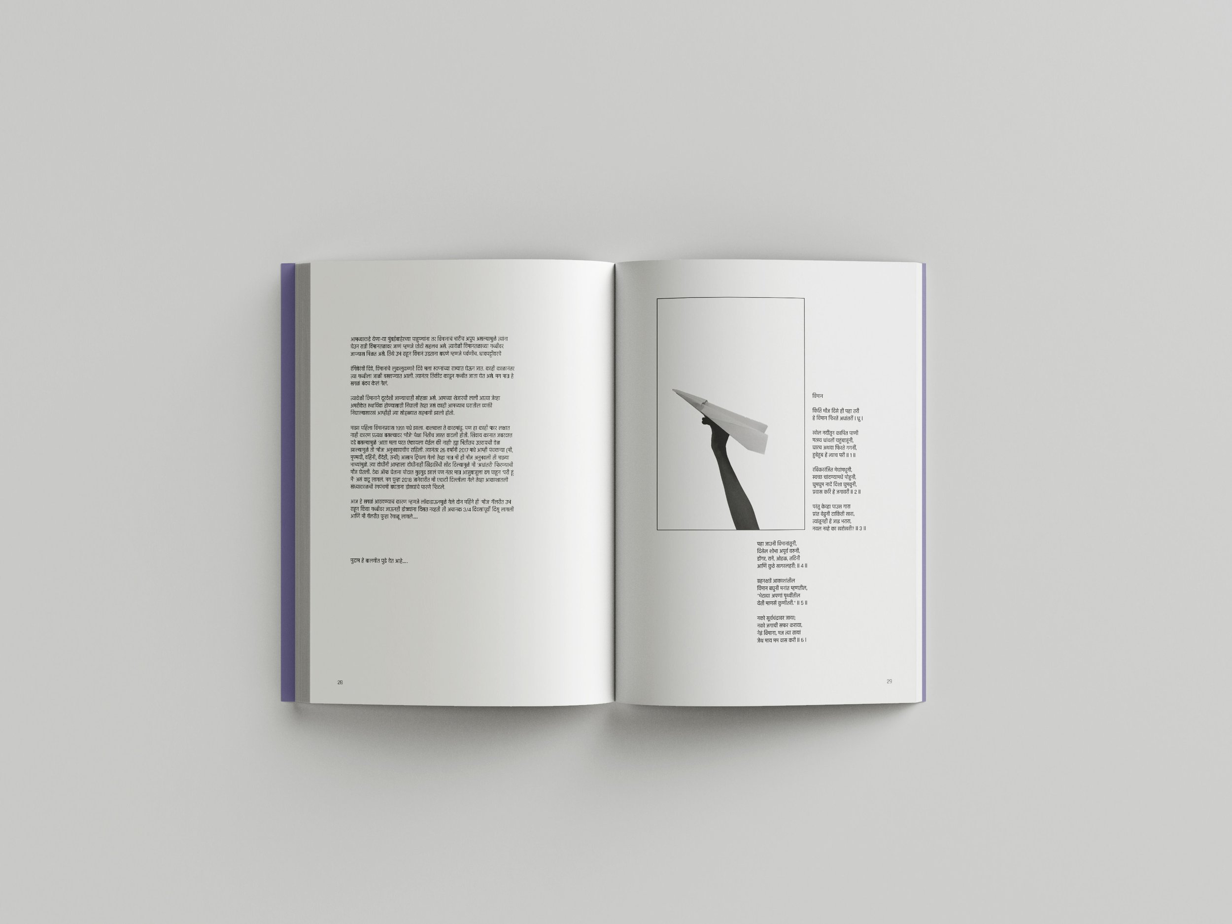 An open book with text in a foreign language, showing a black-and-white image of a hand holding a paper airplane on the right page.