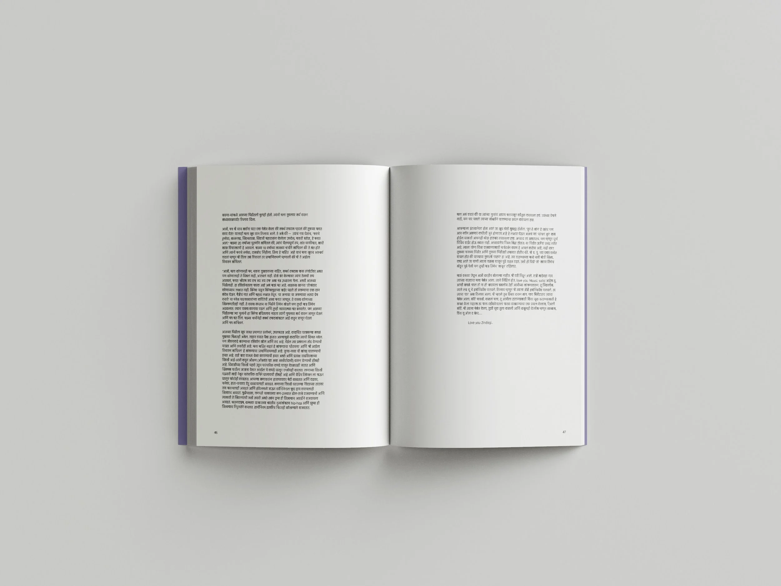 An open book with text in a language that uses Devanagari script, laid flat on a light gray surface.