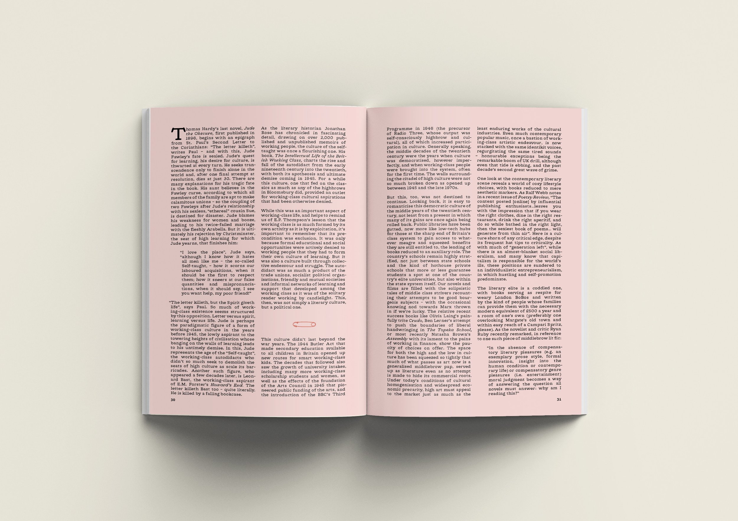 An open magazine with pink pages displaying black printed text on both pages. The magazine is laid flat on a plain, light-colored surface.