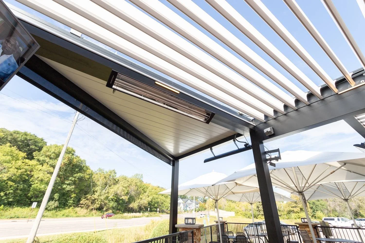 Outdoor pergola by Gary Duff Designs featuring integrated infrared heaters for year-round entertaining