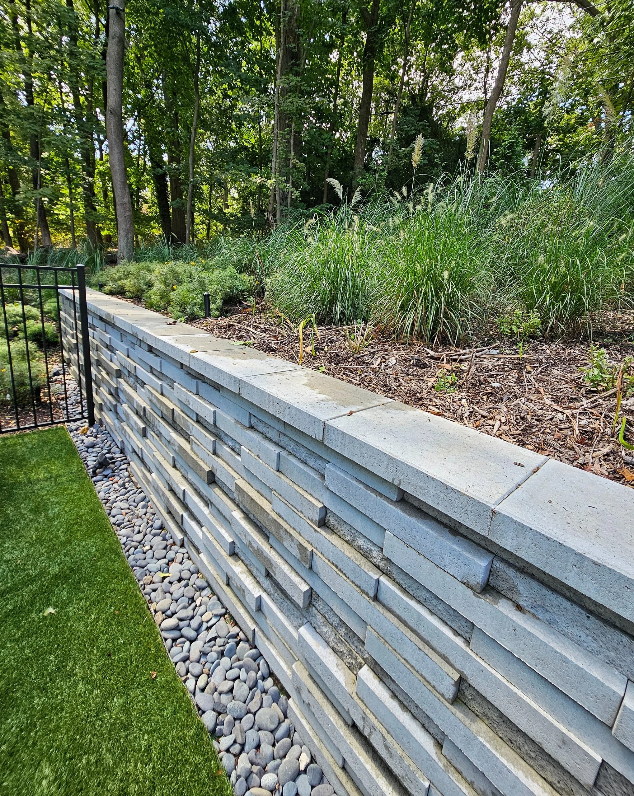 Masonry retaining wall construction providing structural support and landscape definition in Mt. Sinai, NY