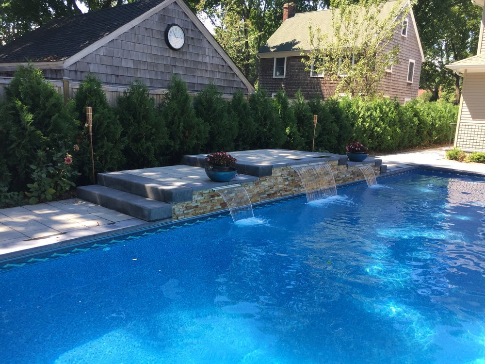 Backyard landscaping with privacy greenery and a neat lawn edge in Port Washington, NY