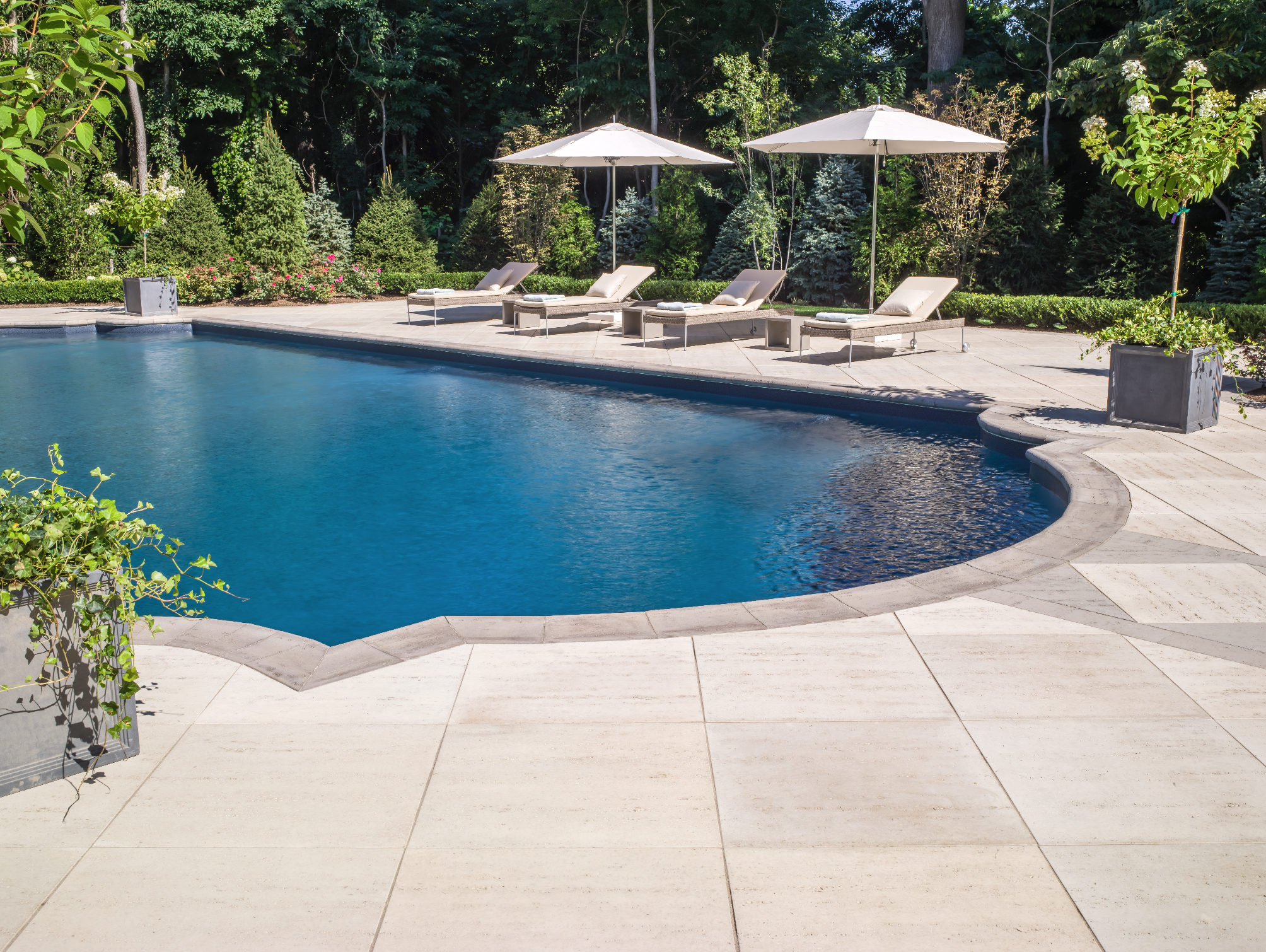 Masonry retaining wall with layered stone texture and proper drainage in Miller Place, NY