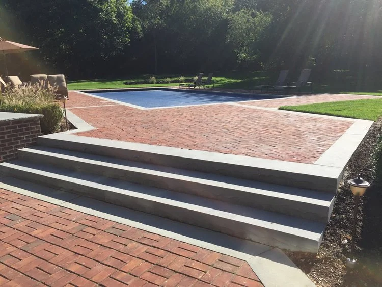 Masonry garden wall and stone columns framing the entry in Manhasset, NY