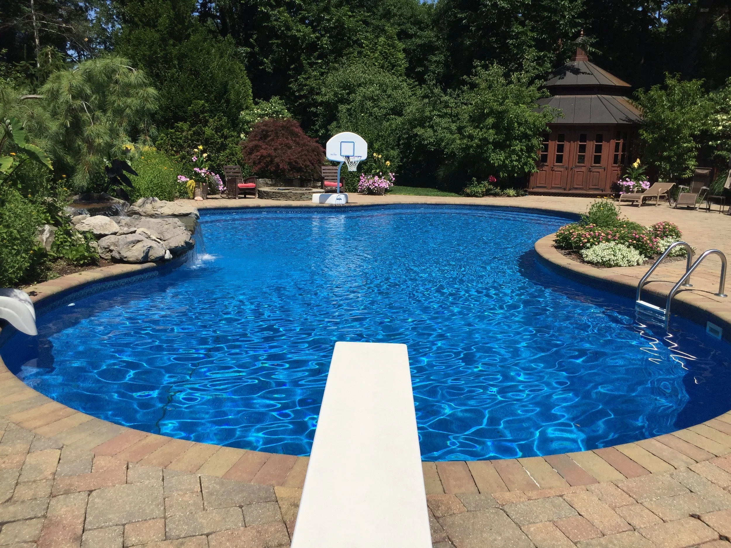 Outdoor fireplace built into a paver patio gathering space in Northport, NY