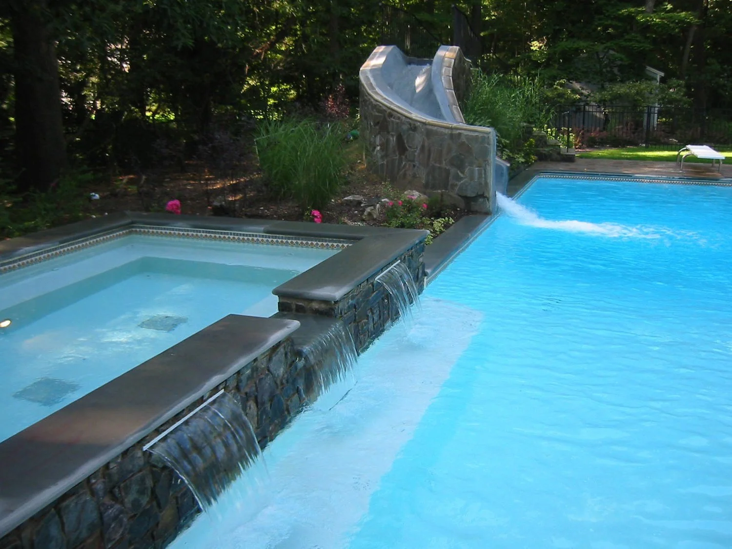Inground Swimming Pool surrounded by tailored hardscape features in Deer Park, NY