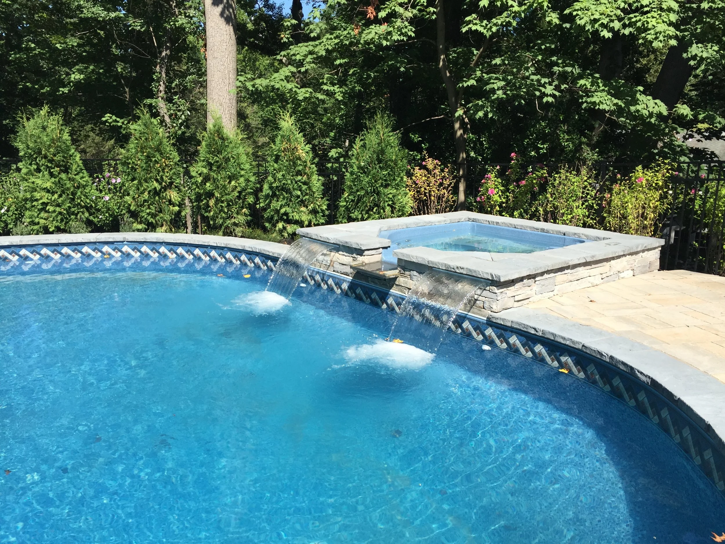 A balanced backyard design that includes a swimming pool and open lawn in Manhasset, NY