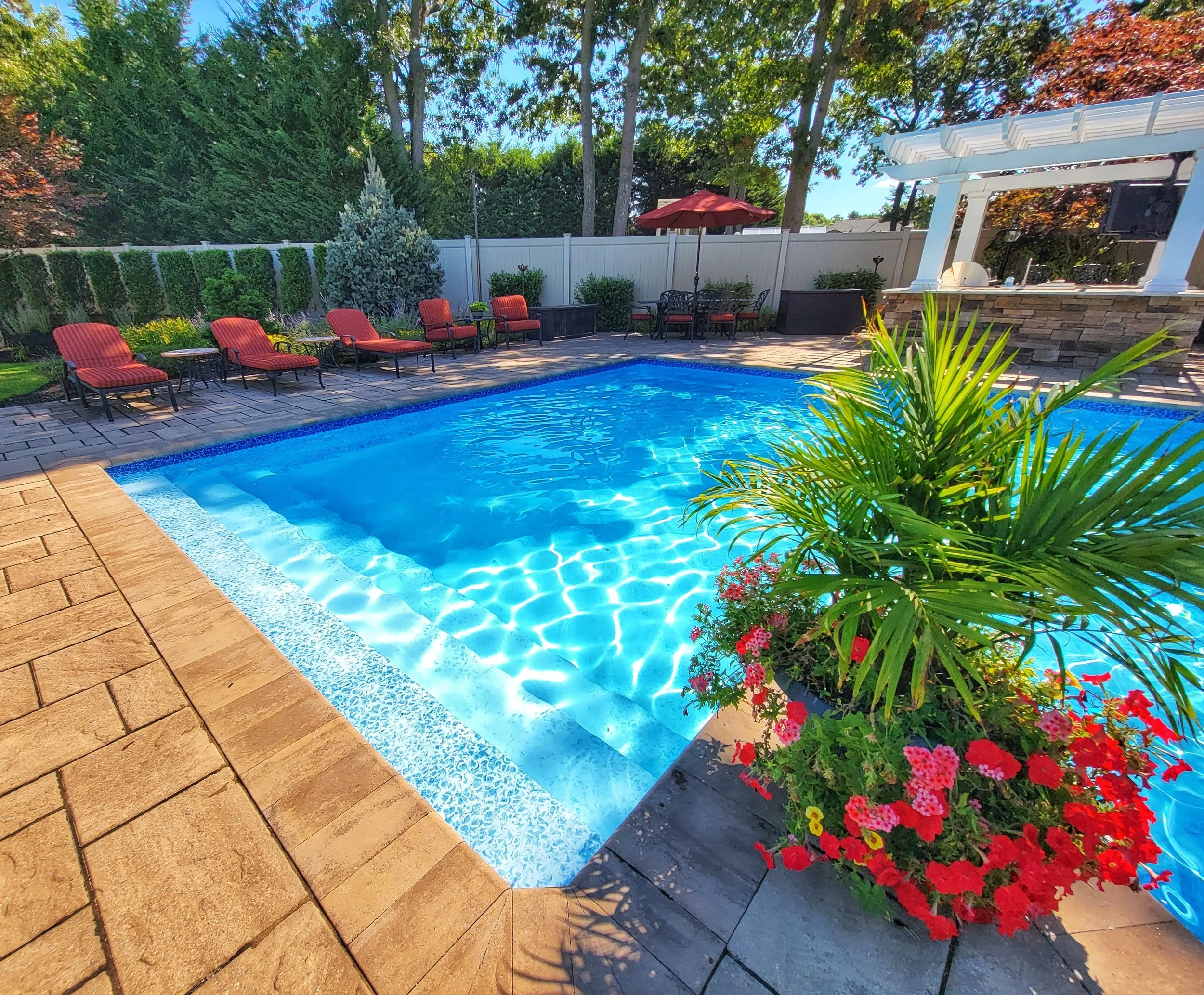 This outdoor space features a swimming pool positioned near open lawn in Smithtown, NY