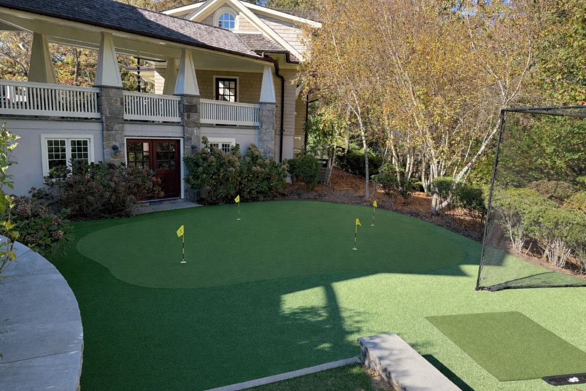 Putting green positioned near a patio lounge space in Port Washington, NY