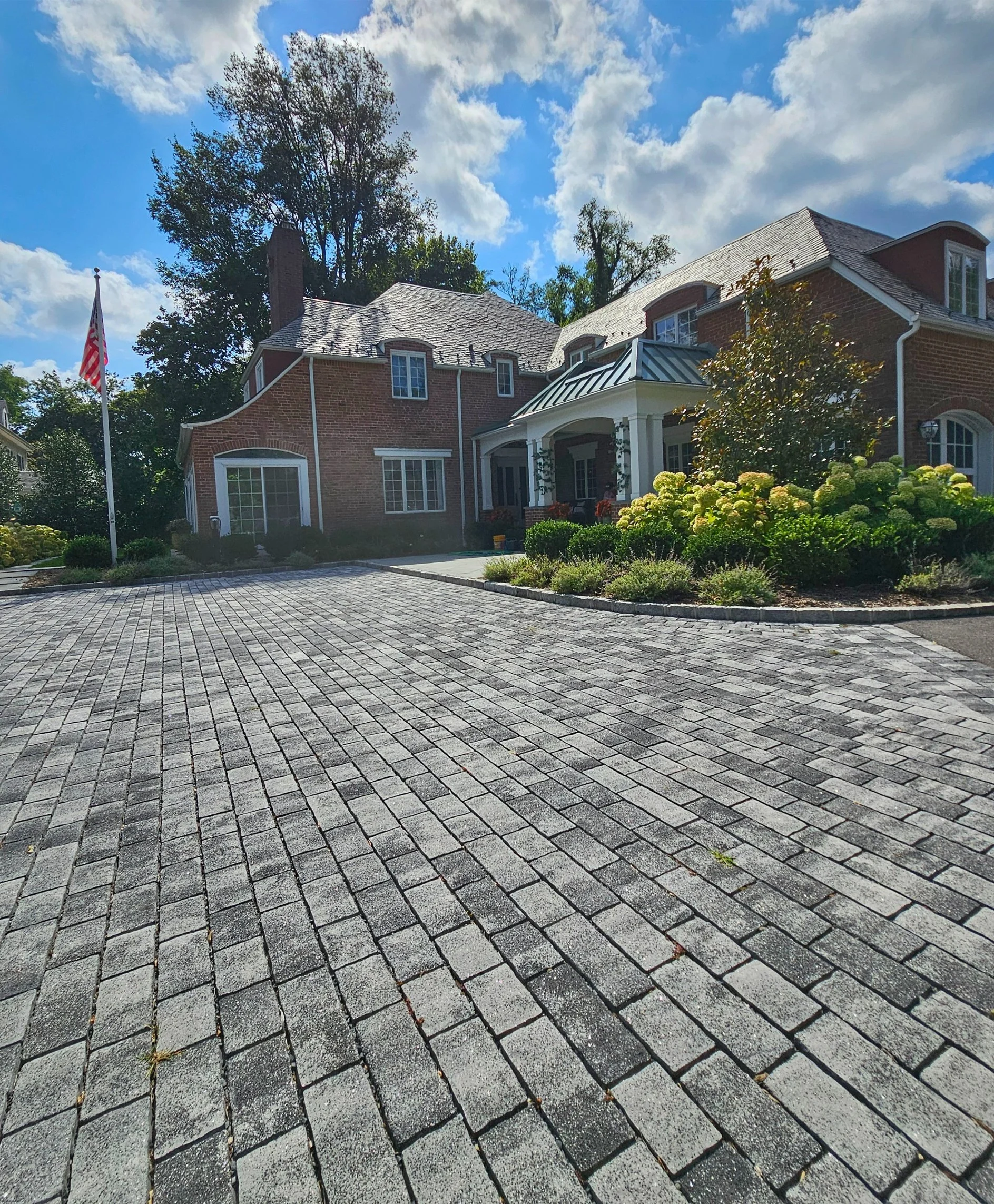 Custom masonry driveway with stone pavers creating a strong and elegant entrance in Syosset, NY