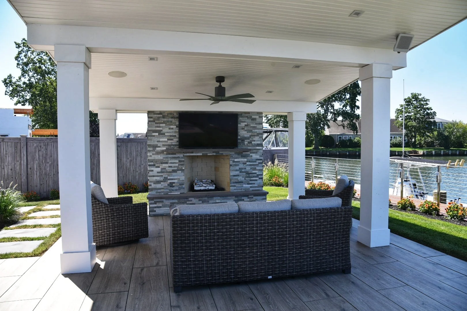 A vertical stone outdoor fireplace designed as a backyard focal point in Cold Spring Harbor, NY