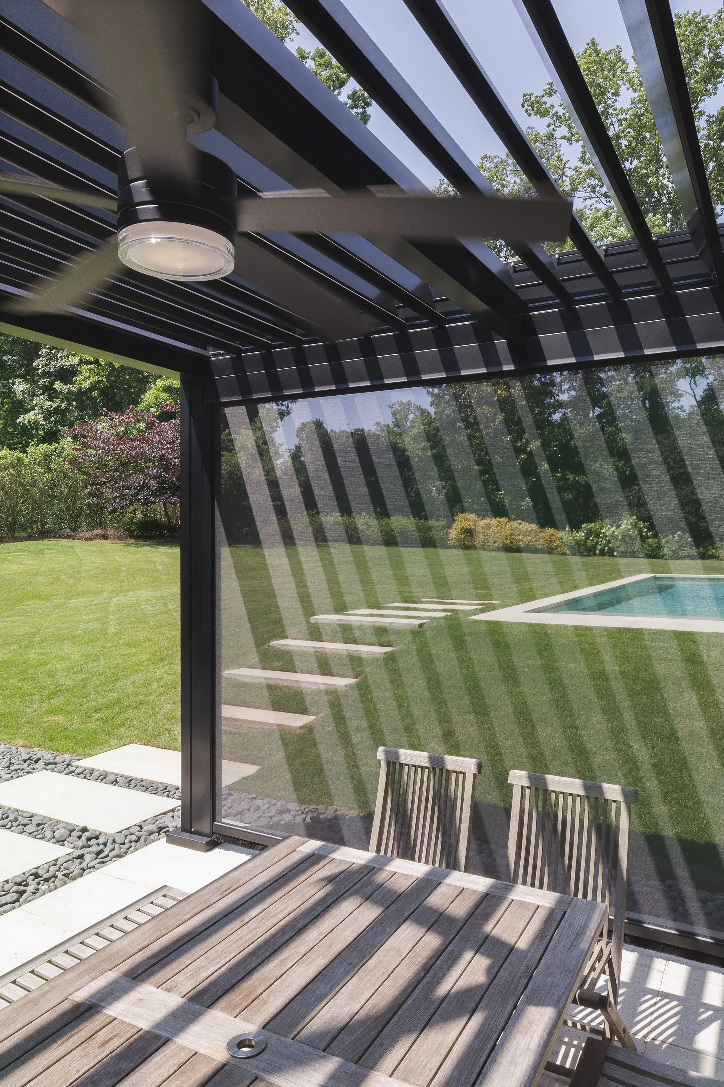 Glass sunroom connected to outdoor kitchen and patio area