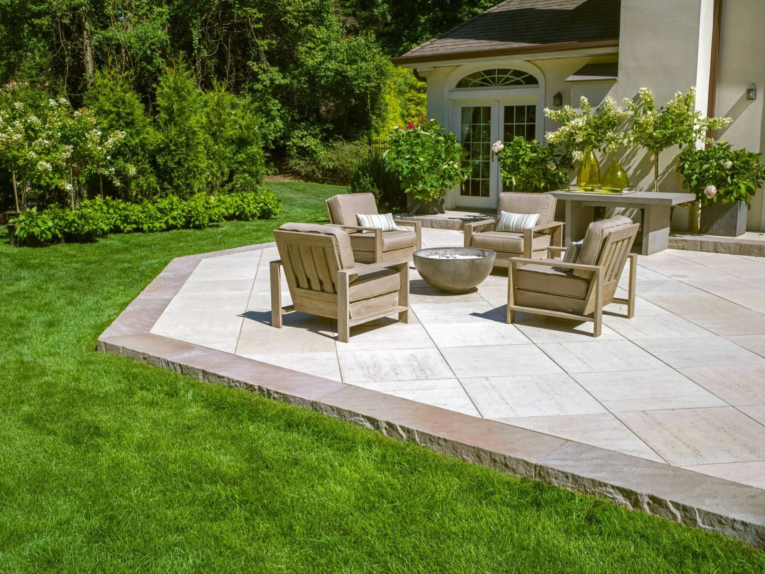Landscape design with stone pathway, shrubs, and flowering plantings in Old Westbury, NY