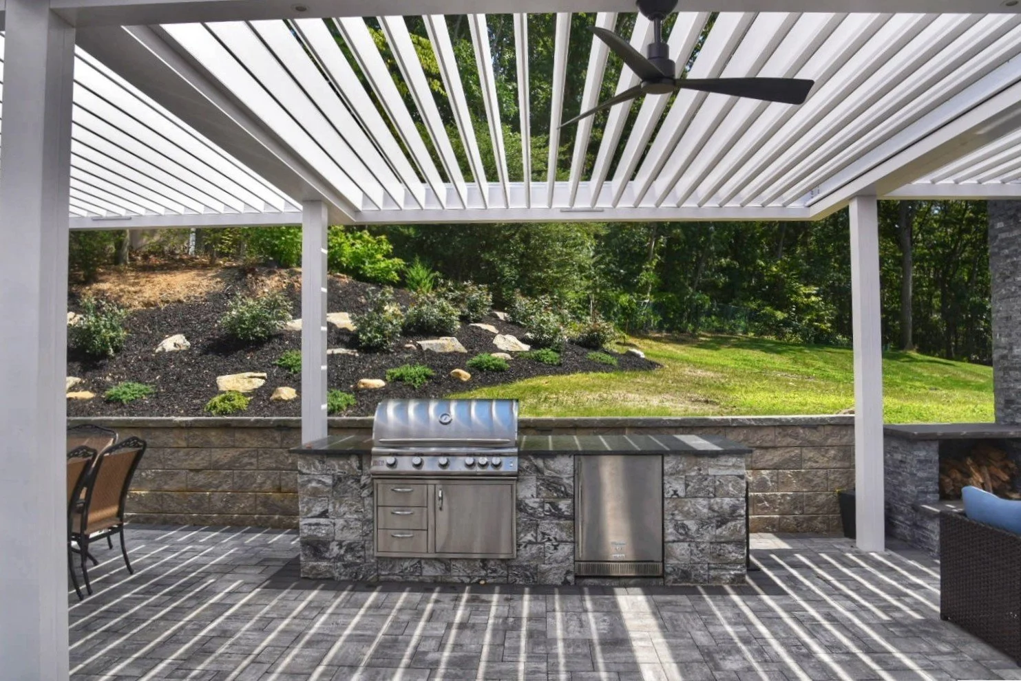 Outdoor water feature and surrounding plantings designed as part of a financed property transformation in Southampton, NY