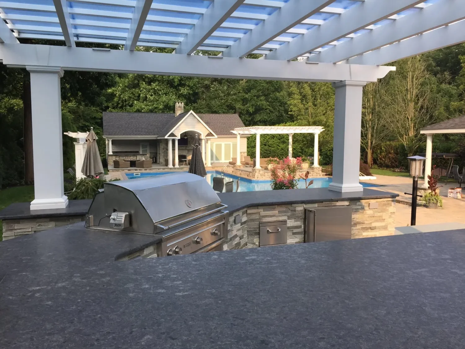 Outdoor kitchen design with built-in grill and stone countertops for entertaining in Babylon, NY