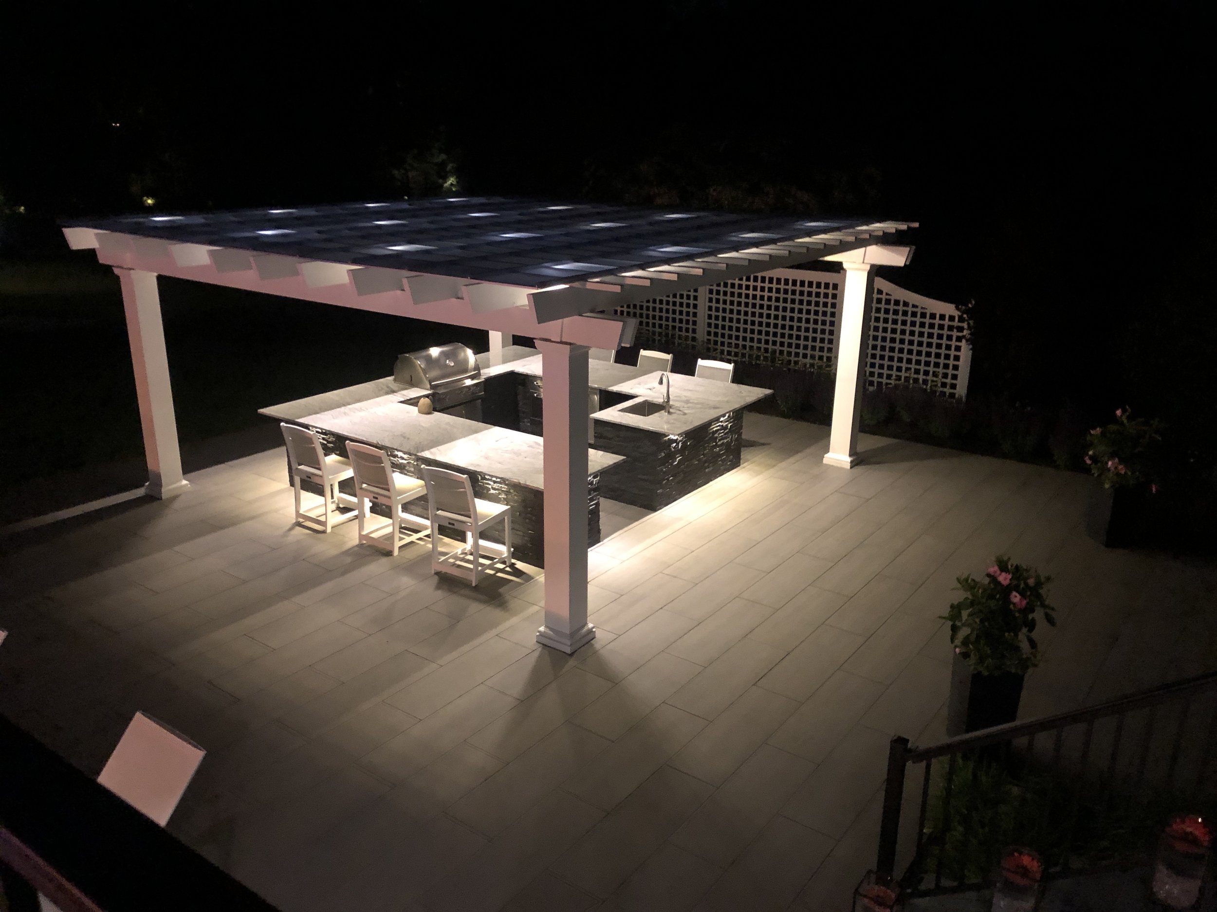 Landscape lighting illuminating garden beds and trees at night in Commack, NY