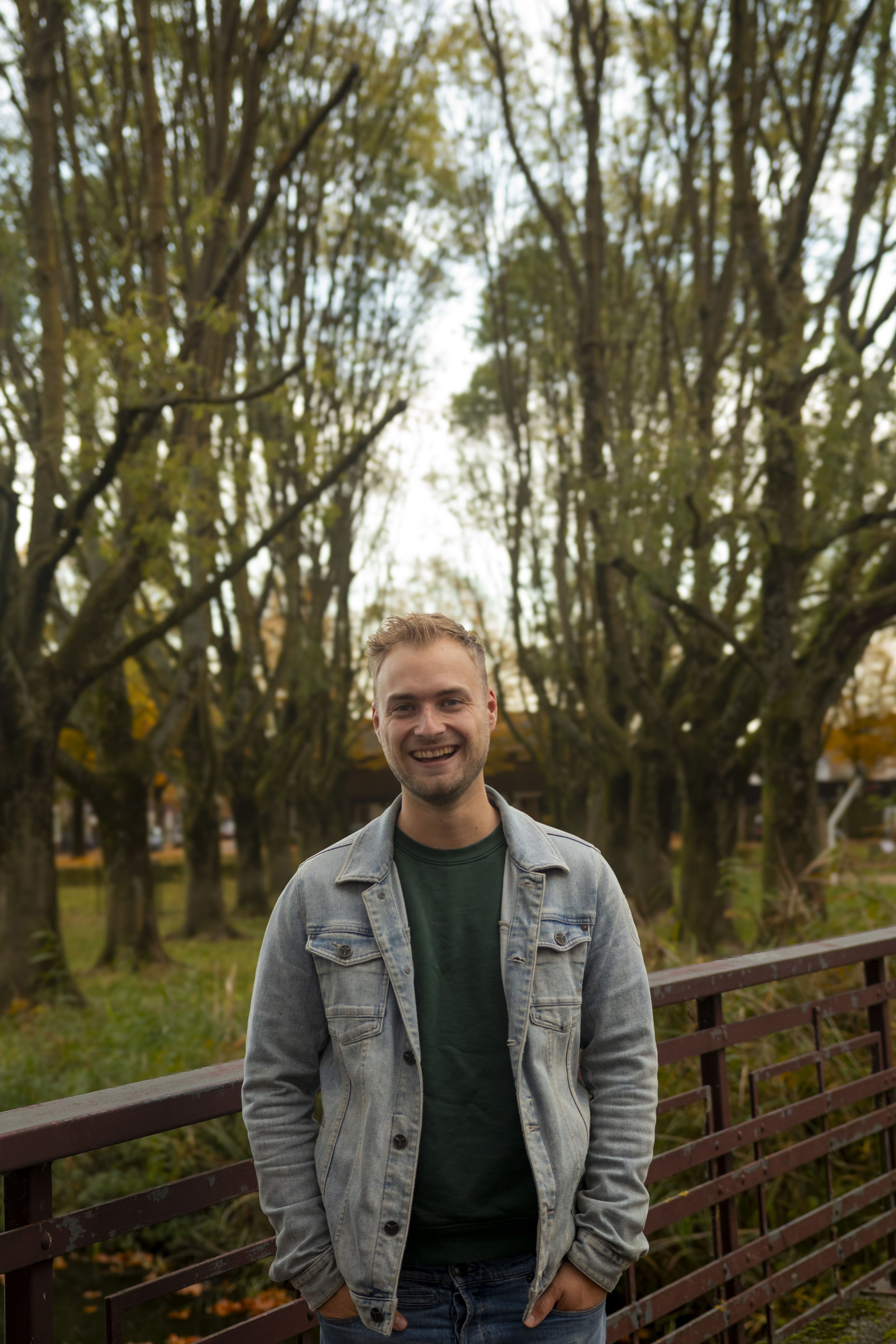 Portret van de interieur bouwer van Tije Interieur, buiten gefotografeerd tussen groen en herfstkleuren. Toegankelijke en vriendelijke uitstraling, passend bij persoonlijk en klantgericht maatwerk interieur.