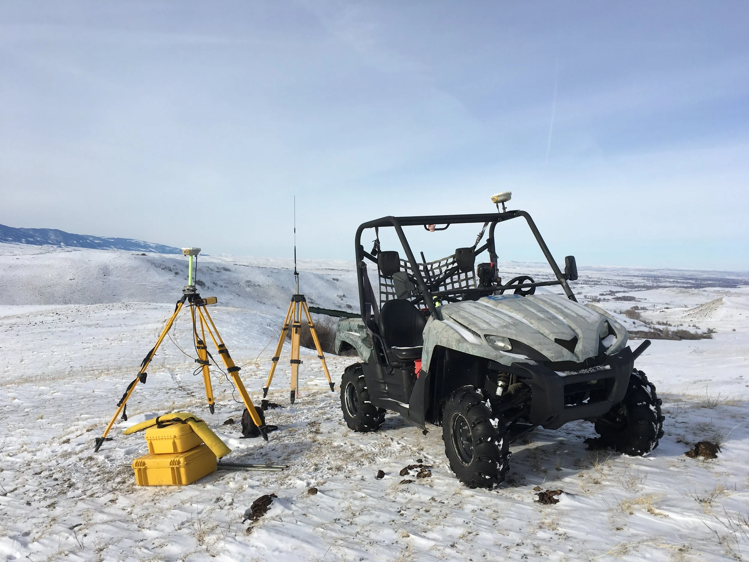 Survey vehicle with equipment in snowy landscape.