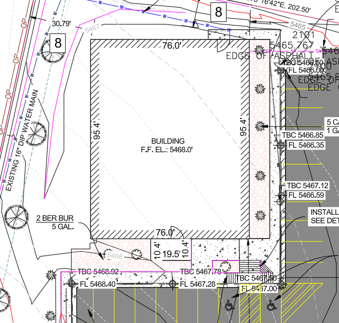 Detailed site plan featuring a building, water main, parking spaces, and various topographical and construction annotations.