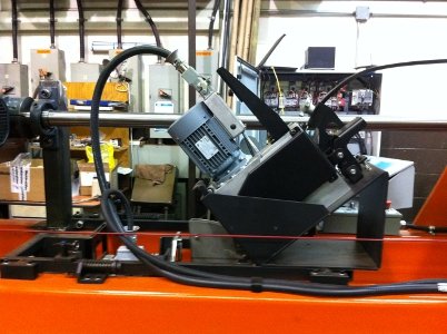 Industrial machinery with robotic arm and control panel in a manufacturing setting.