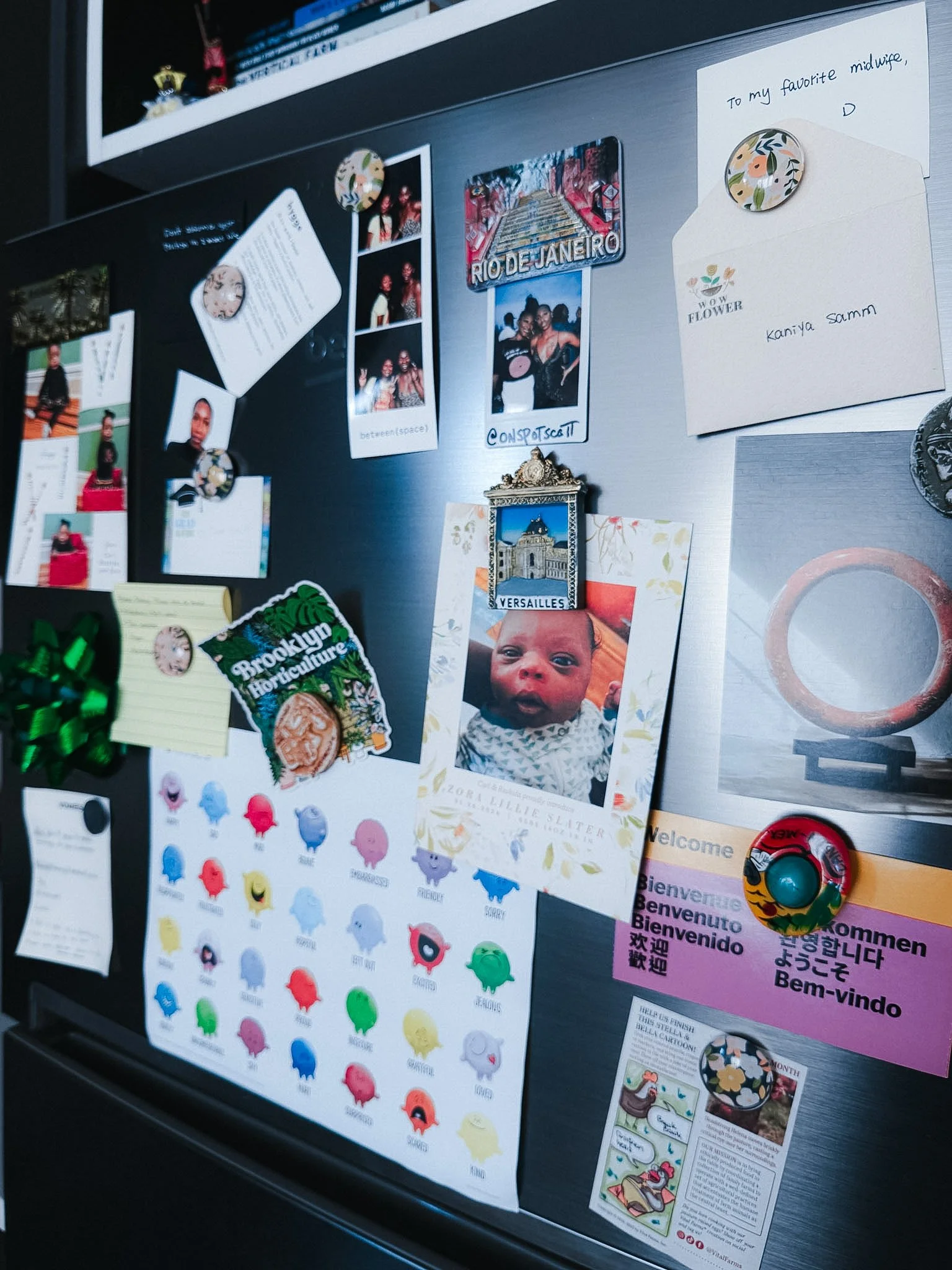 The refrigerator door is covered with various magnets, photos, notes, and greeting cards.