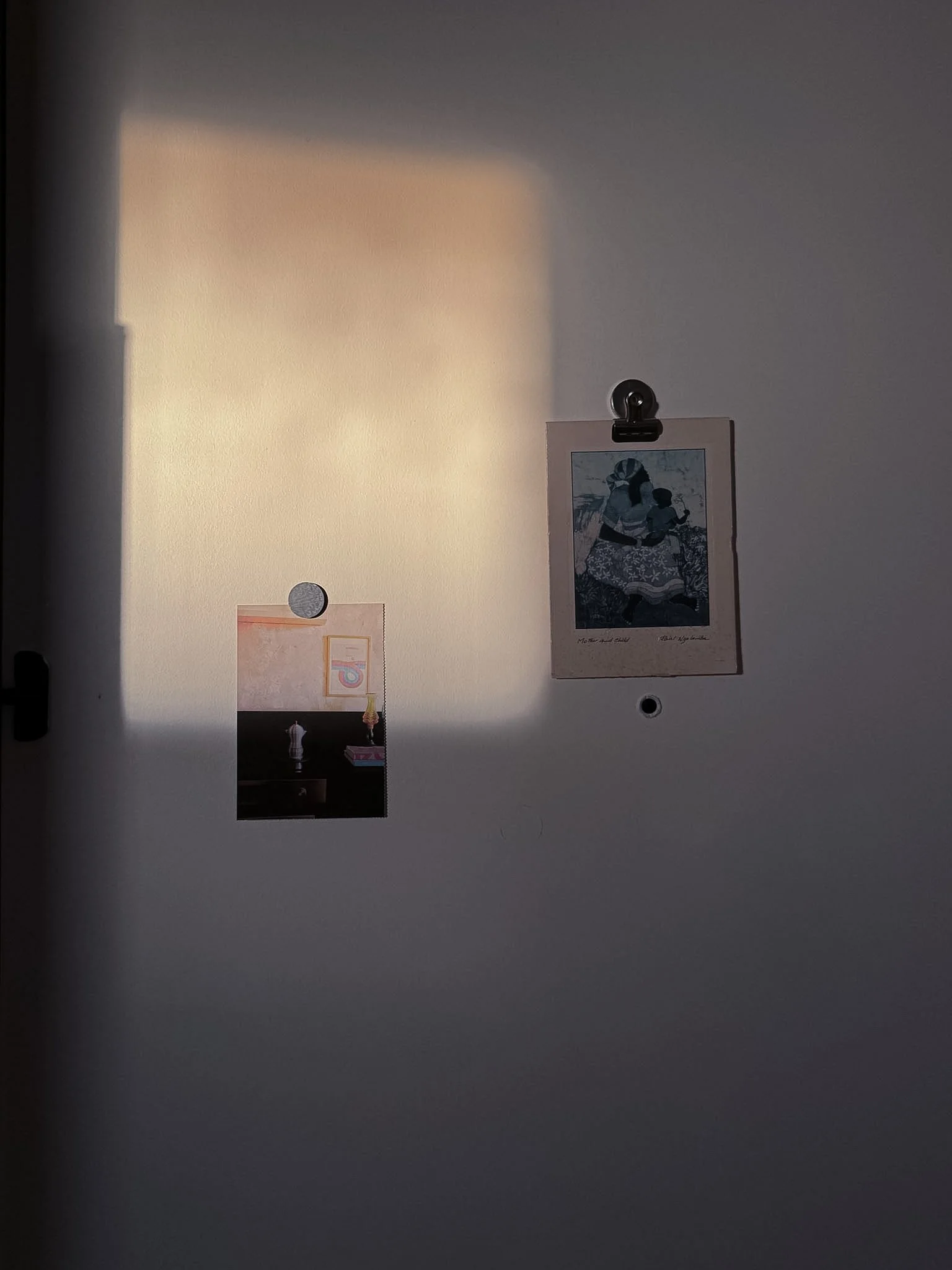 Small framed pictures and a hanging clip, with light and shadow creating a gradient effect.