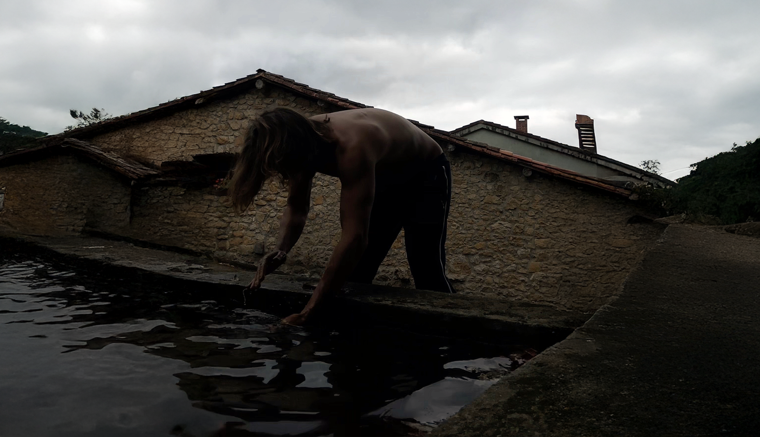 hombre lavandose las manos en una fuente asturiana