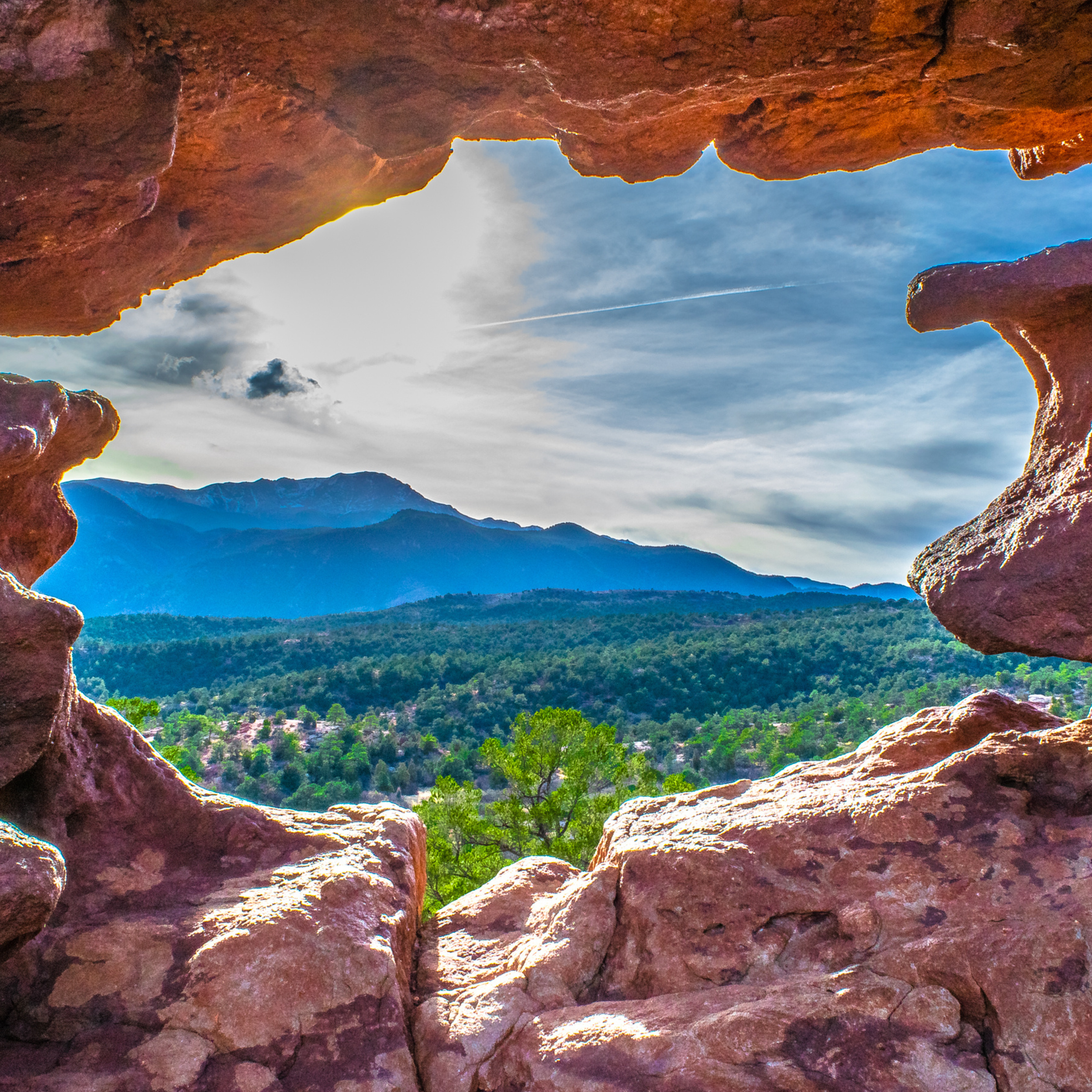View of mountains and forest through a natural rock window.