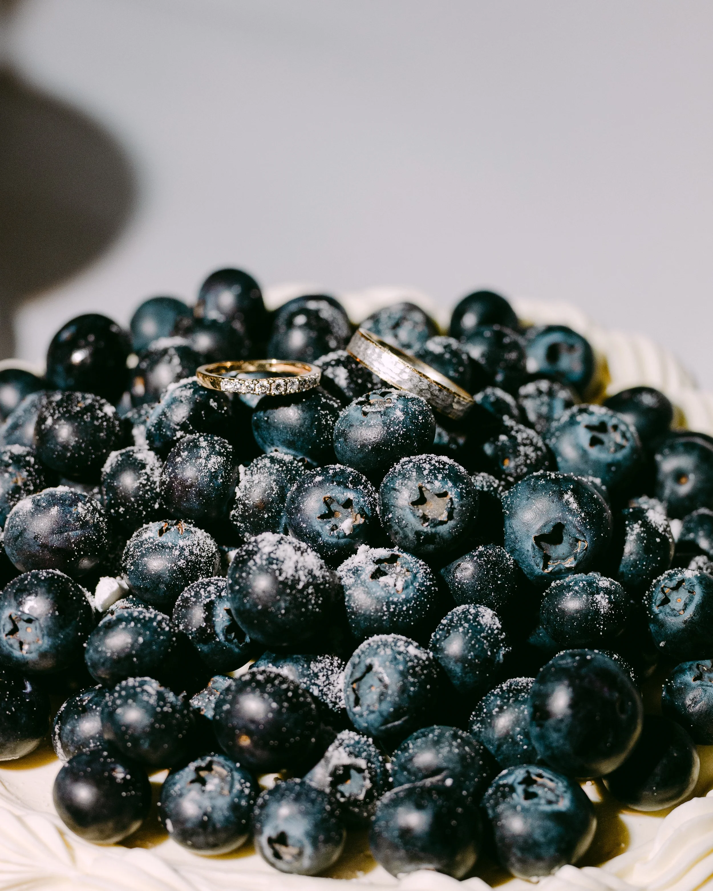 Une tarte décorée de myrtilles avec deux alliances posées dessus