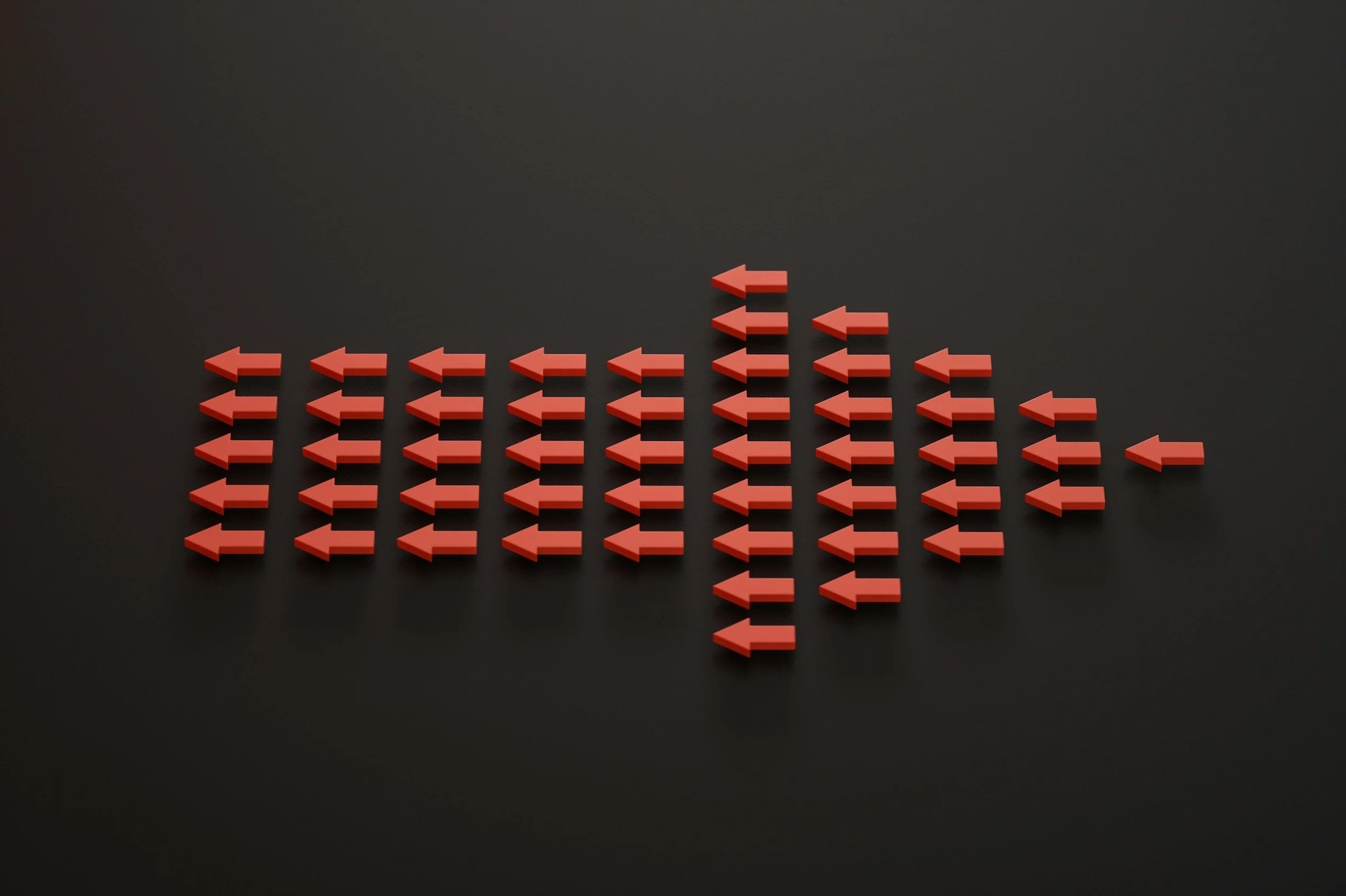 Multiple red arrow-shaped objects pointing to the left, arranged in a pattern on a black background.
