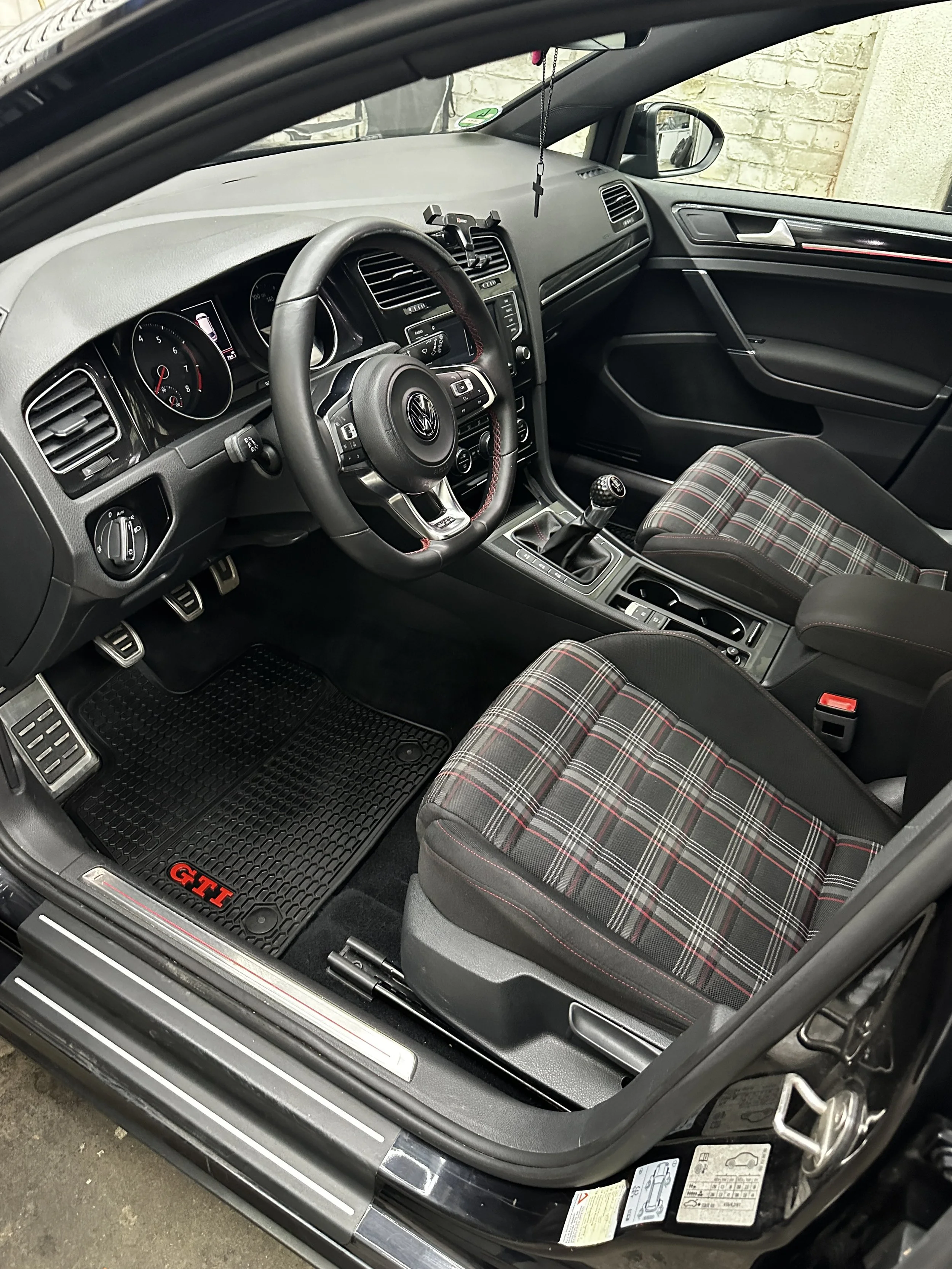 Innenraum eines VW Golf GTI mit Schaltknüppel, Poloshirt-Sitz und Armaturenbrett
