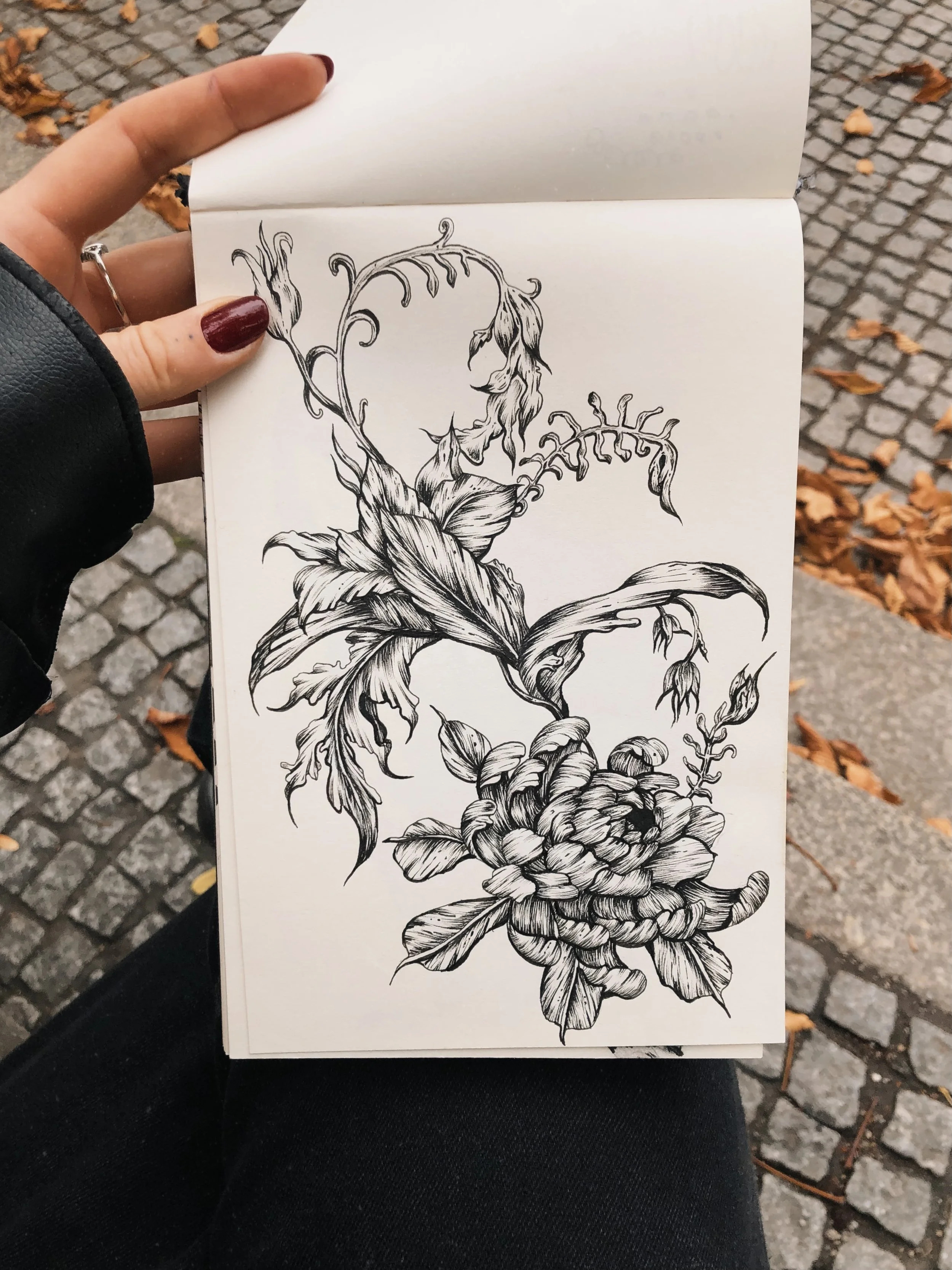 Schwarz-weiß-Tattoo-Design einer Blume mit Blättern und Ranken.