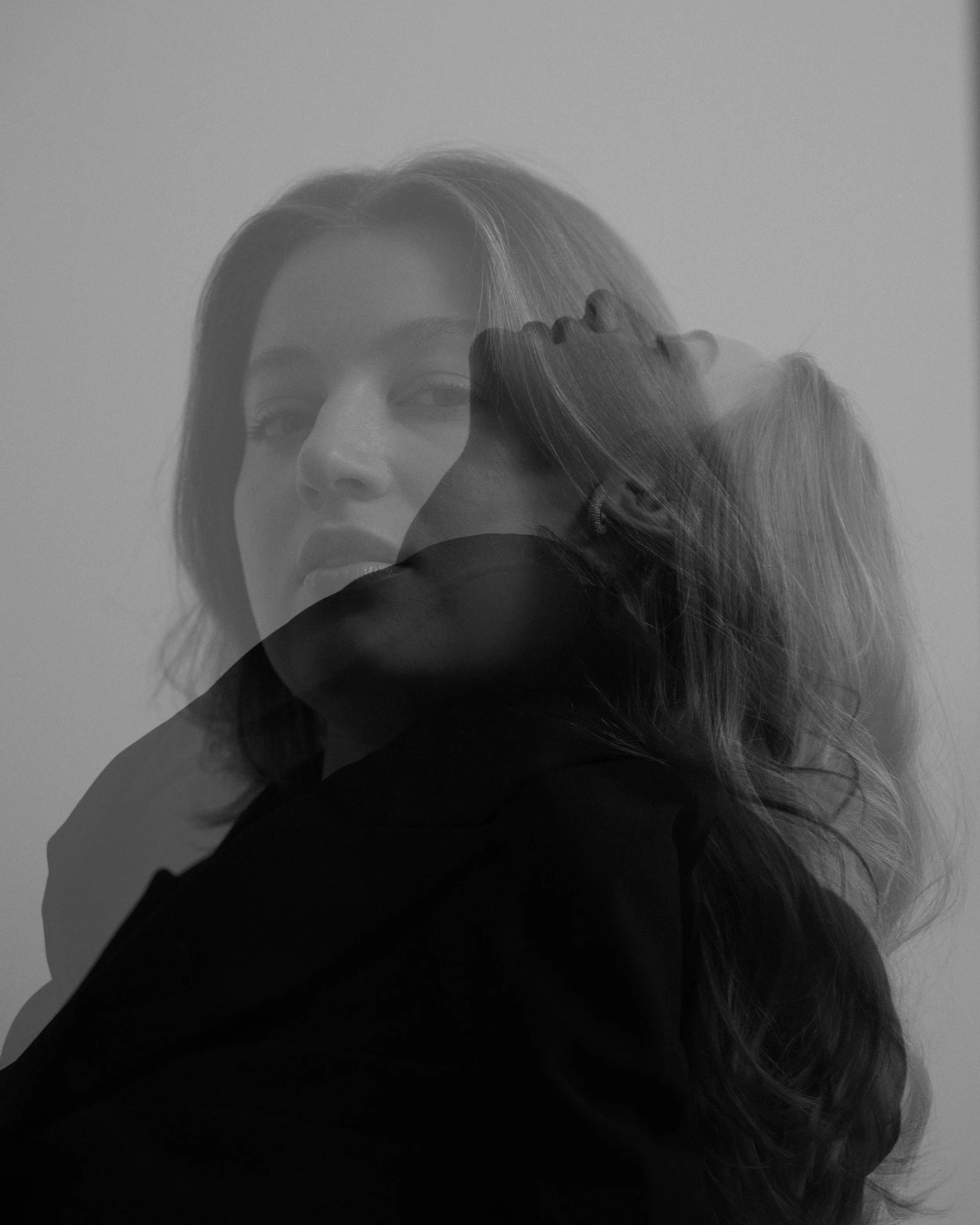 Mehrfach belichtetes Schwarz-Weiß-Foto von zwei Frauen, die in entgegengesetzten Richtungen blicken und sich teilweise überlappen.