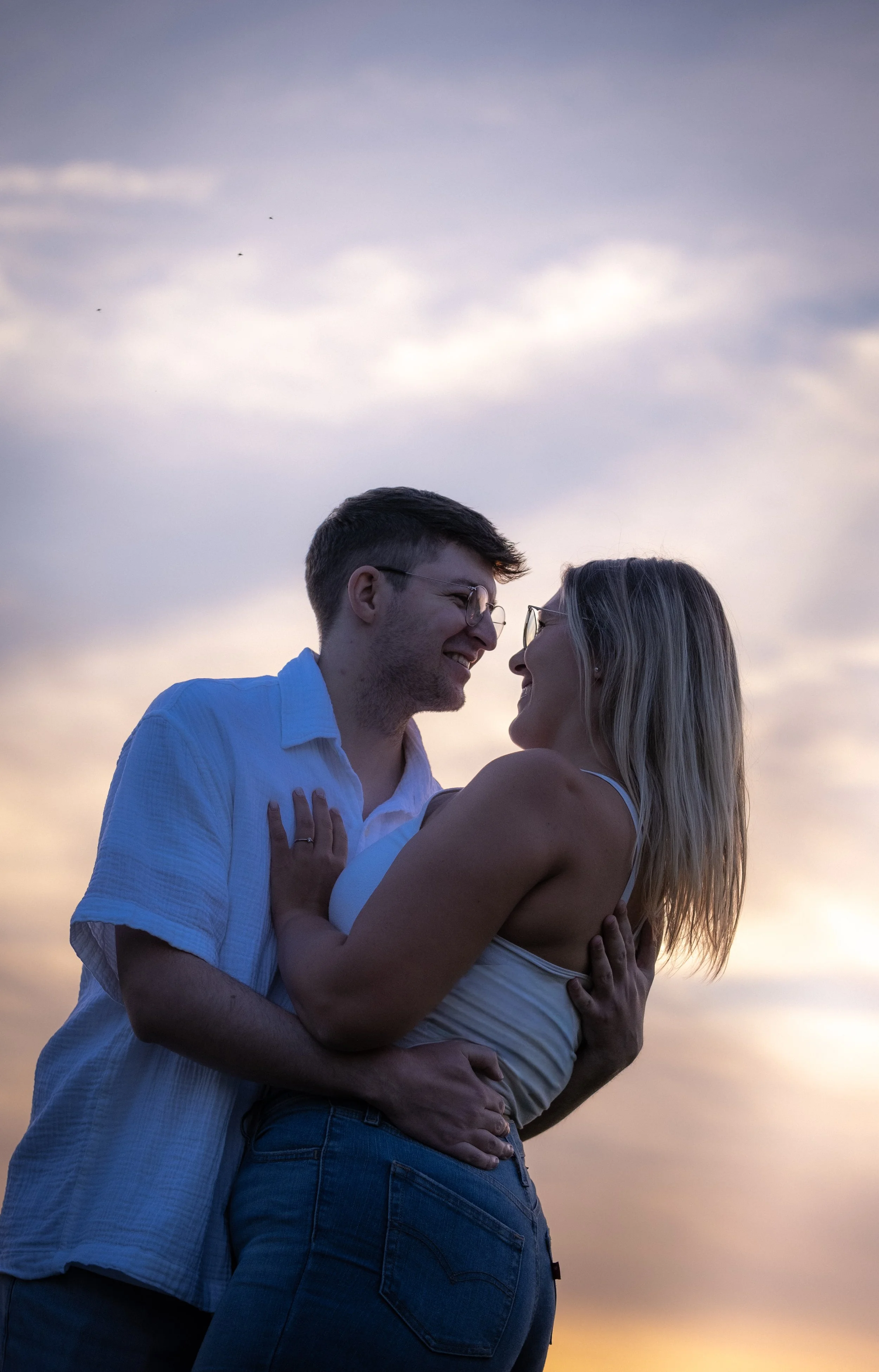 Ein verliebtes Paar umarmt sich bei Sonnenuntergang am Himmel.