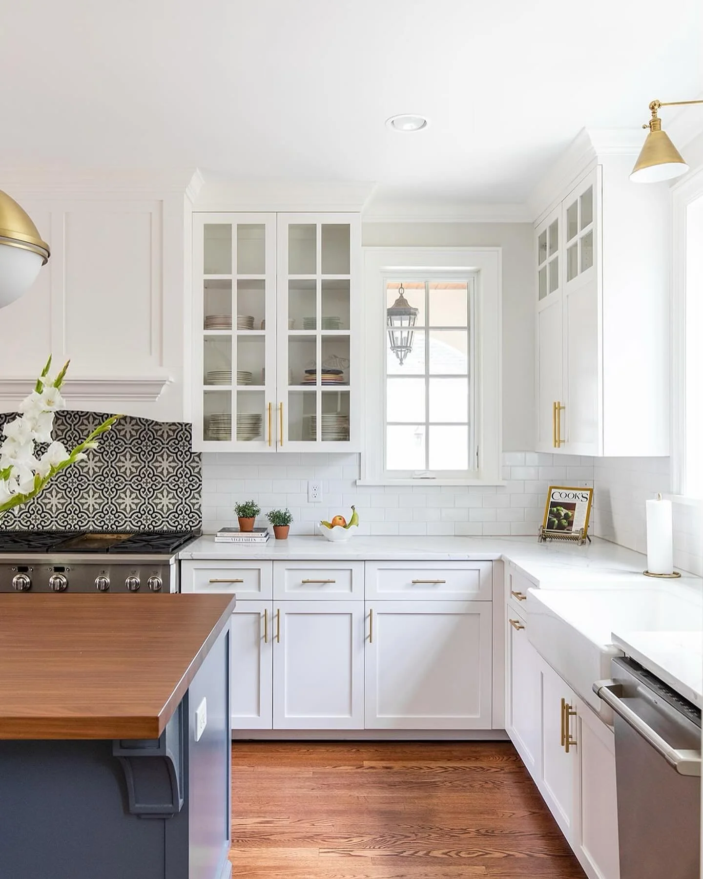 Celebrating the start of the Paris Olympics with one of our favorite kitchens that oozes French charm &amp; sophistication.  Classic navy and white cabinetry, natural wood, unique tile choices, and brass touches; c'est magnifique🌲

📷: @bettyclicker