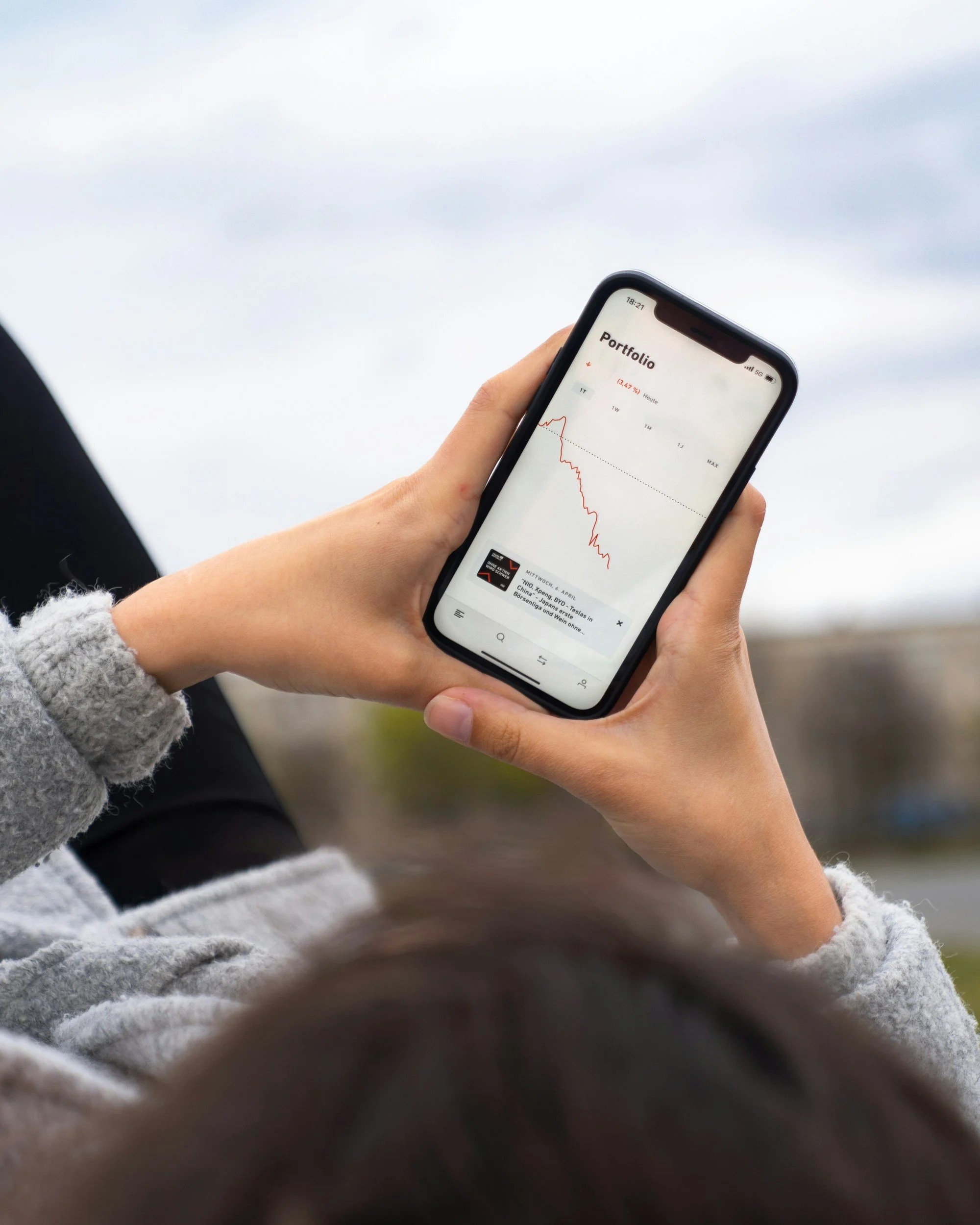 a person looking at a stock dropping on their phone