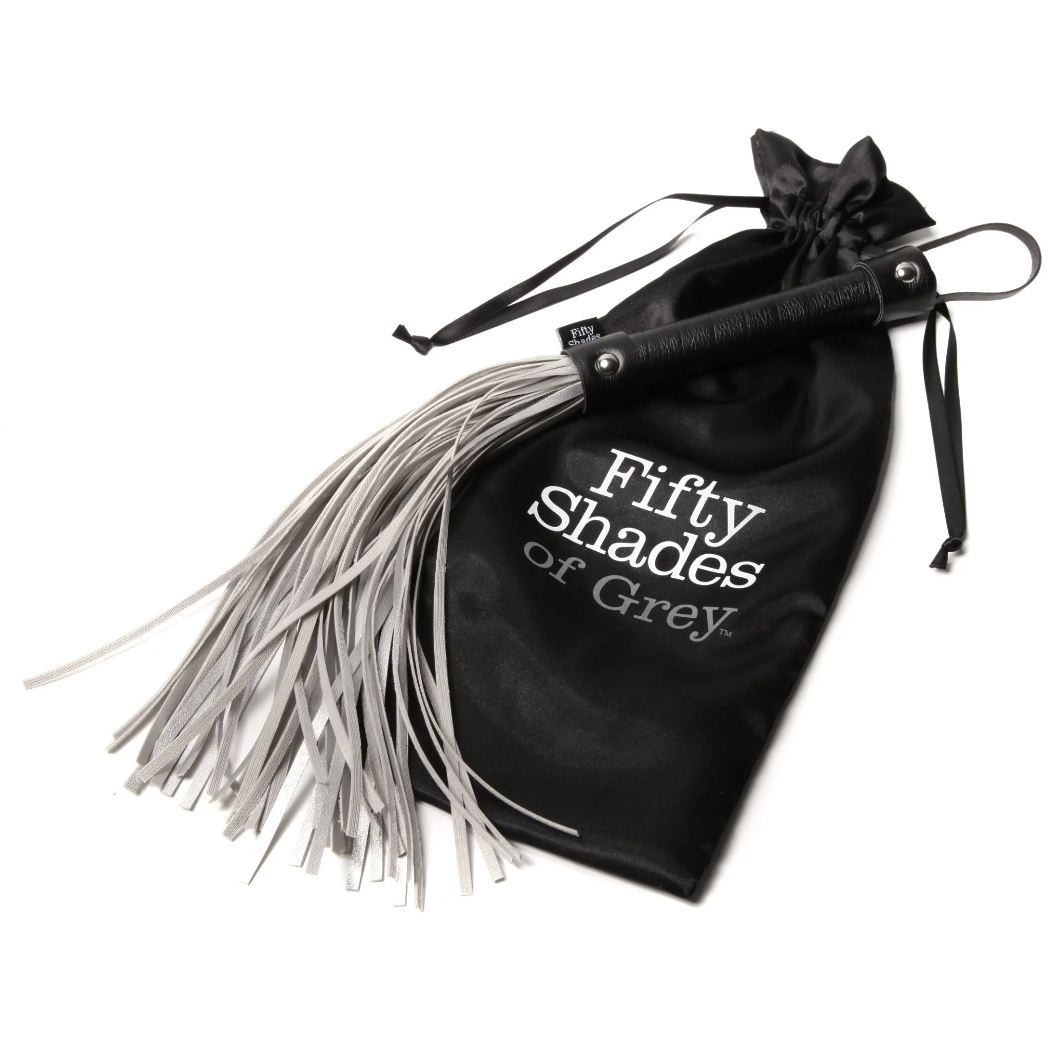 A black flogger with multiple white leather strands, resting on a black drawstring bag labeled 'Fifty Shades of Grey'.