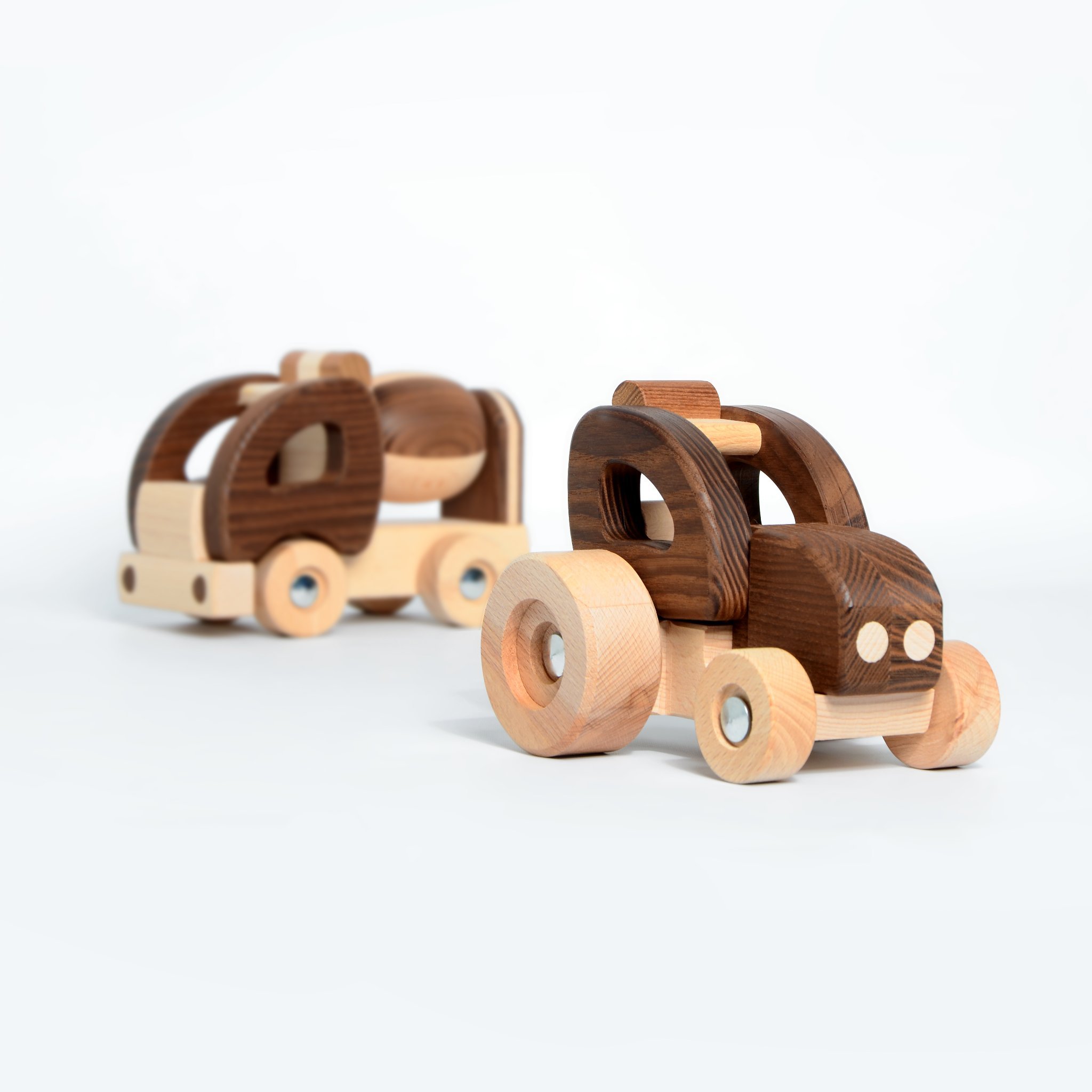 Two wooden toy cars, made of light and dark wood, placed on a white background.