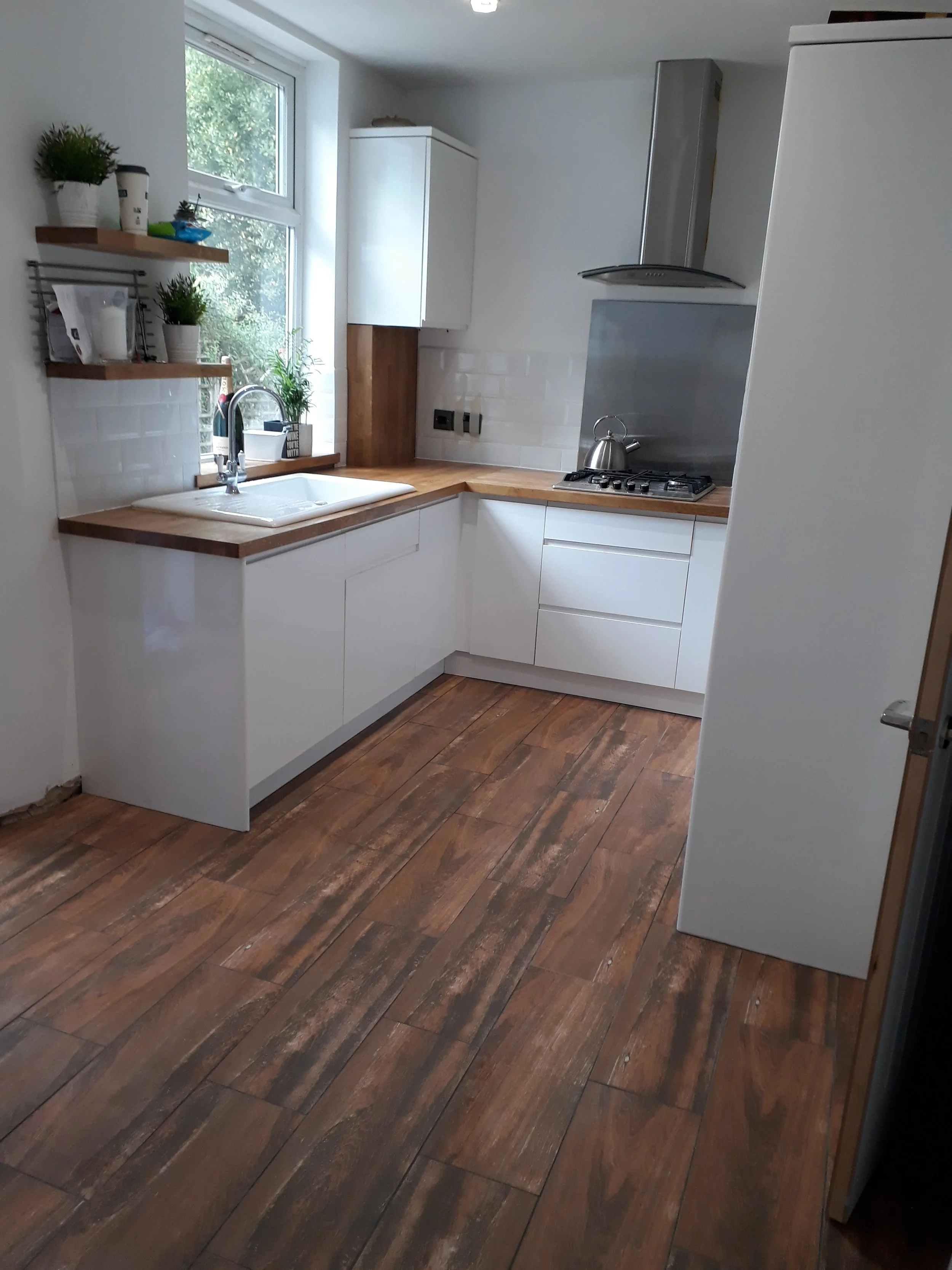 Magasfényű, fehér fogantyú nélküli konyhabútor, tölgy, Osmoval kezelt munkapulttal. Kerámia mosogatóval.  Baal Design