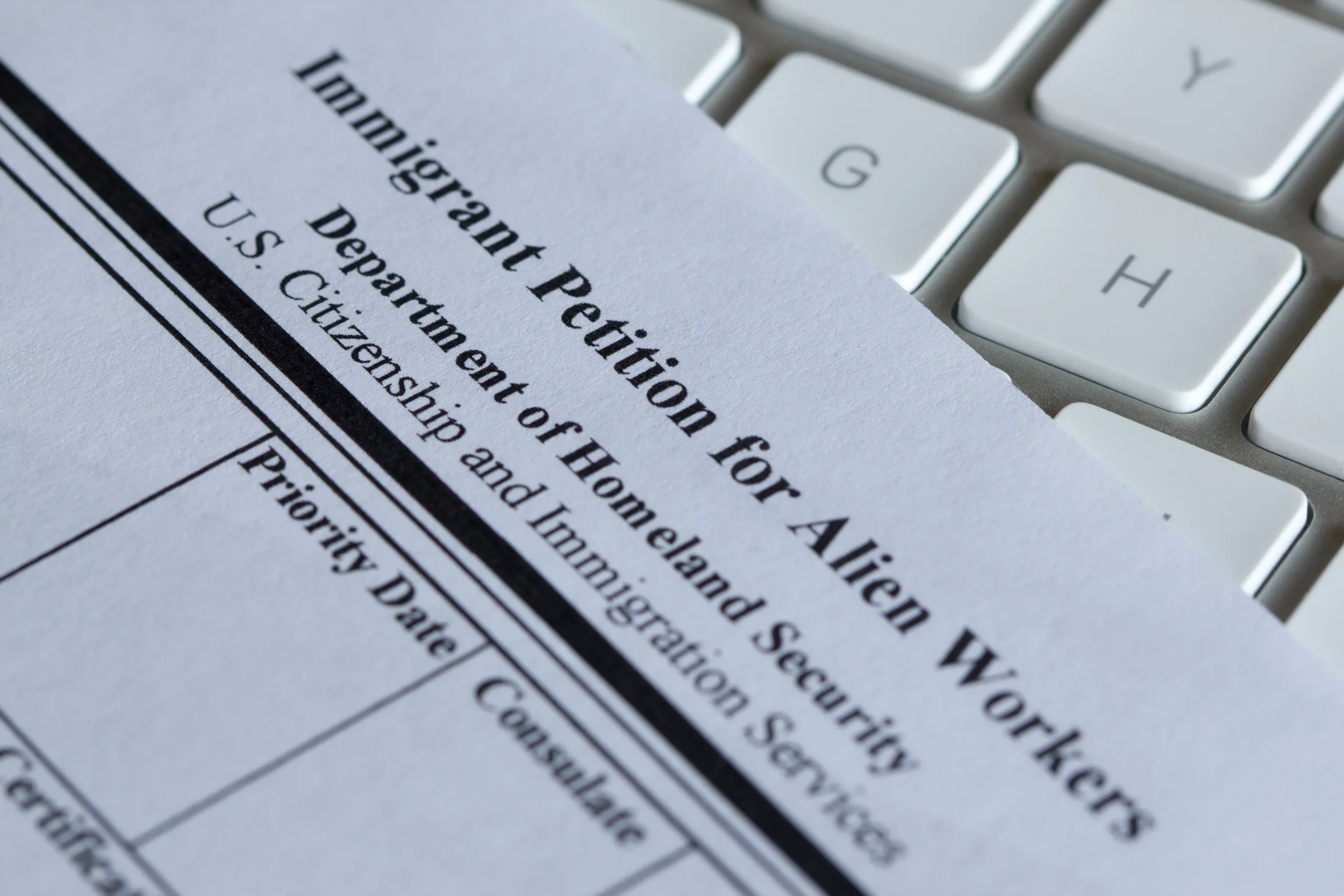 U.S. Department of Homeland Security immigration form partially visible on a white keyboard.