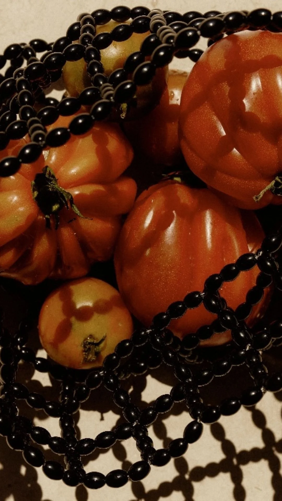 Artistic photo of tomatoes in a black beaded bag