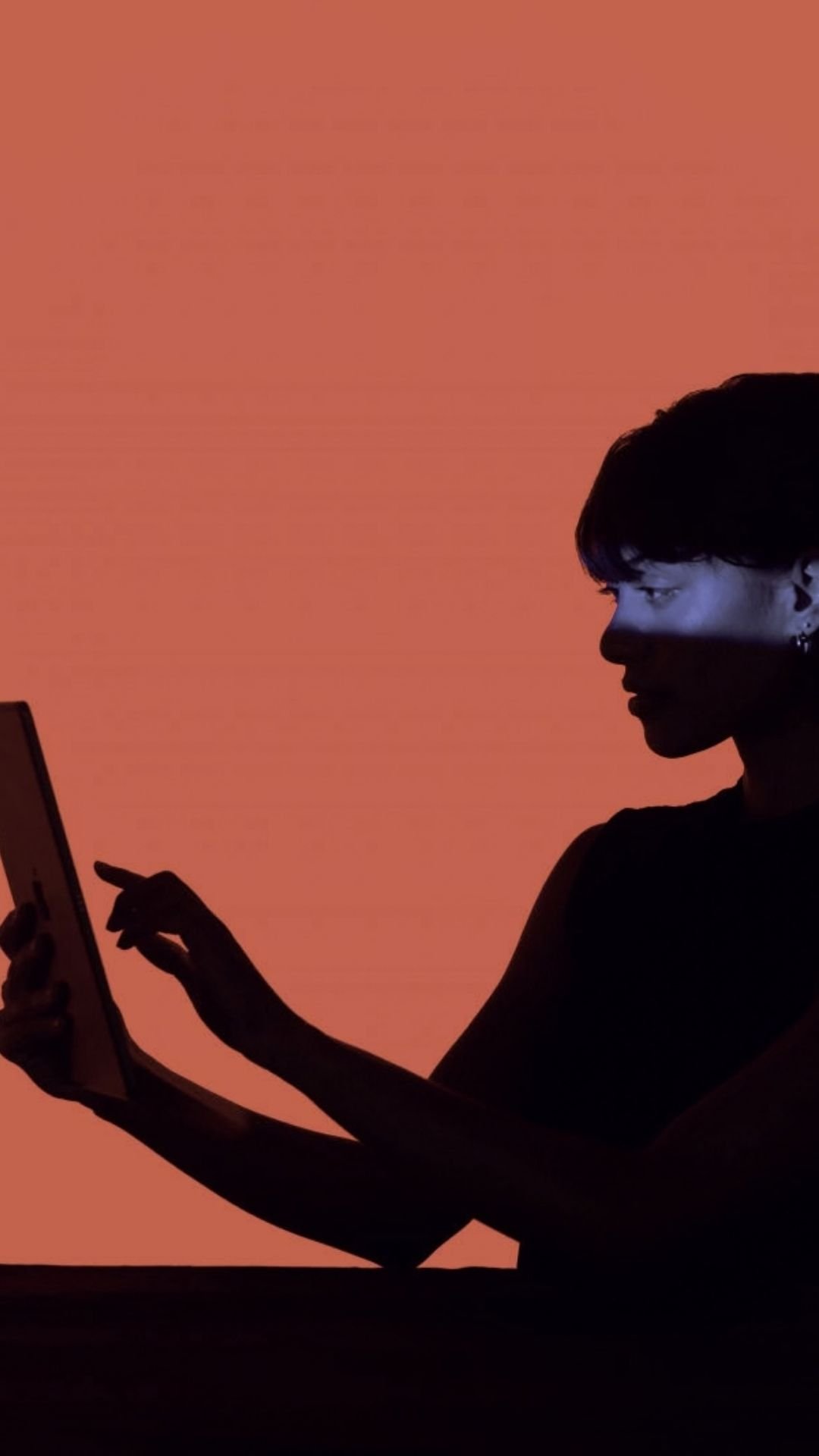 Woman reviewing functional lab test results on a tablet on a orange background