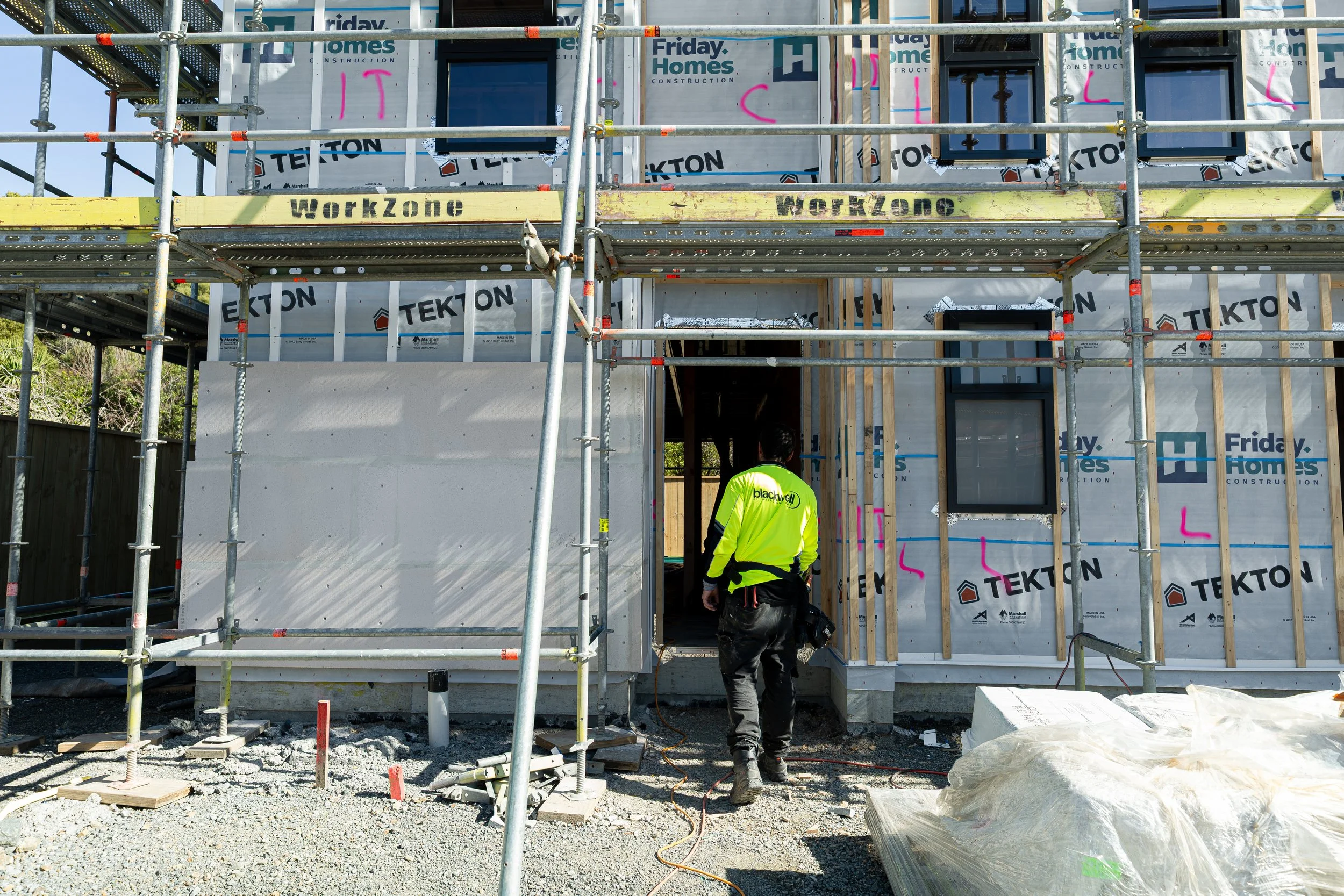 A Blackwell Plumbing and Gas employee walking into a house under construction.