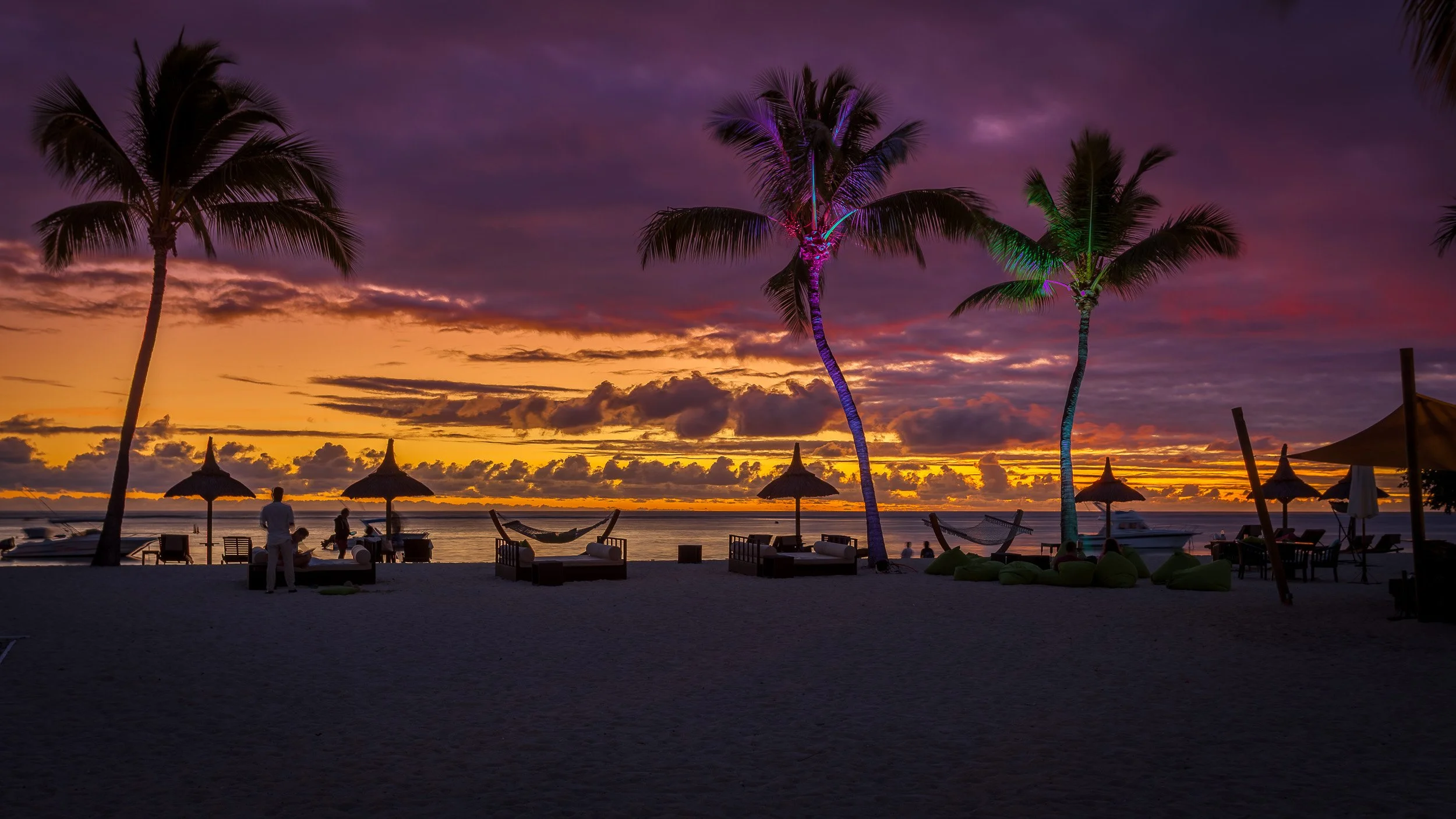 Flic en Flac Beach in Mauritius – palm trees, soft waves and a tranquil tropical shoreline photographed at sunset.