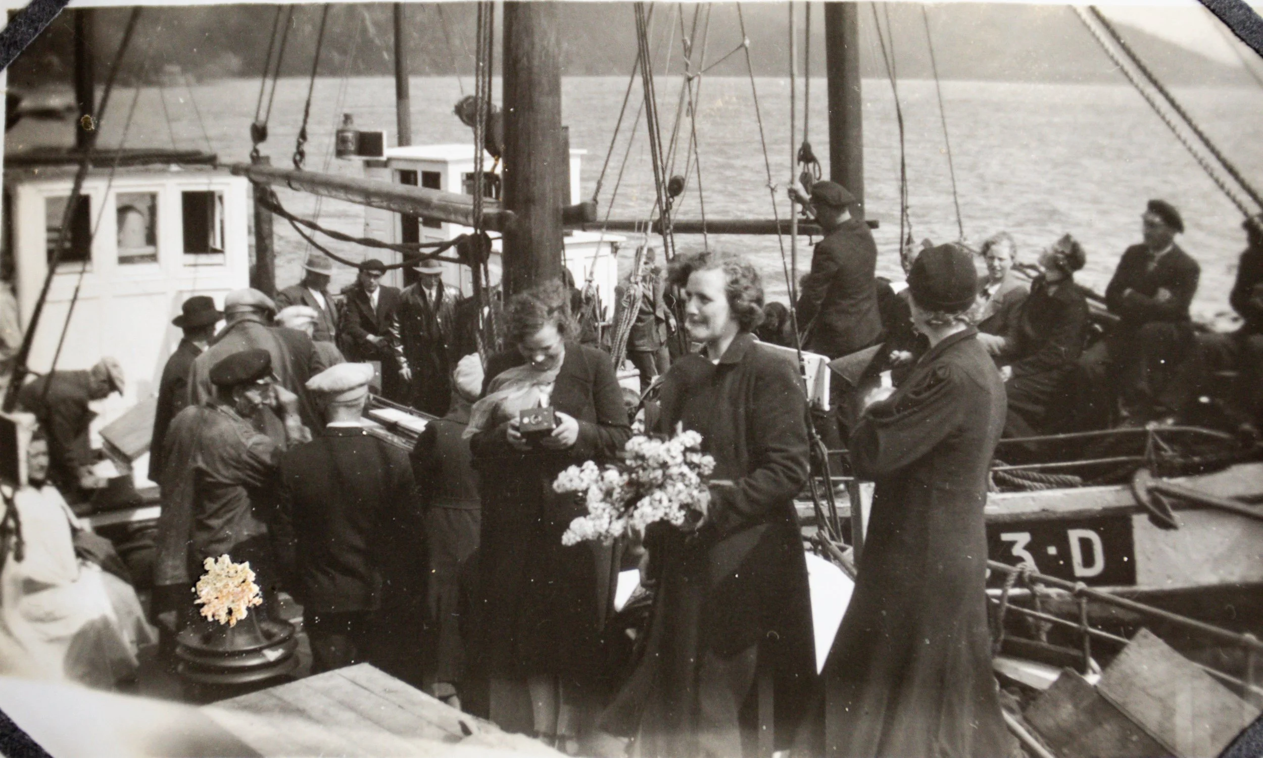 Bryllupsgjester om bord på kutteren «Hovdenes» SF-52-D. Bildet er etter all sannsynlighet tatt ved Blaksetnausta i Innvikfjorden i 1938, på samme sted og ved samme anledning som bildet av det samlede bryllupsfølget. I forgrunnen står to kvinner, den 