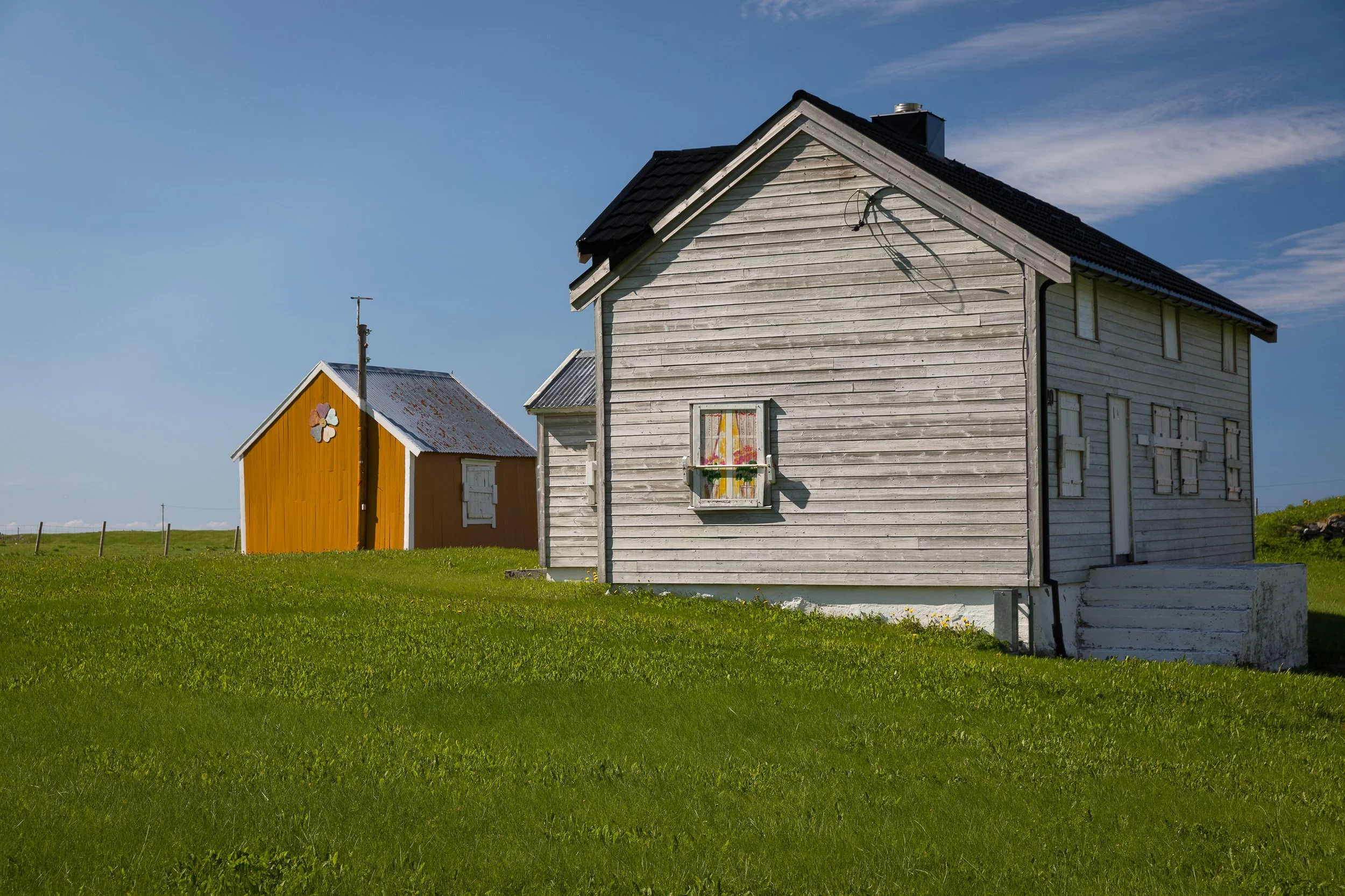 Cabin in the Lofoten Islands, Norway – solitary wooden house facing the sea with mountains behind.