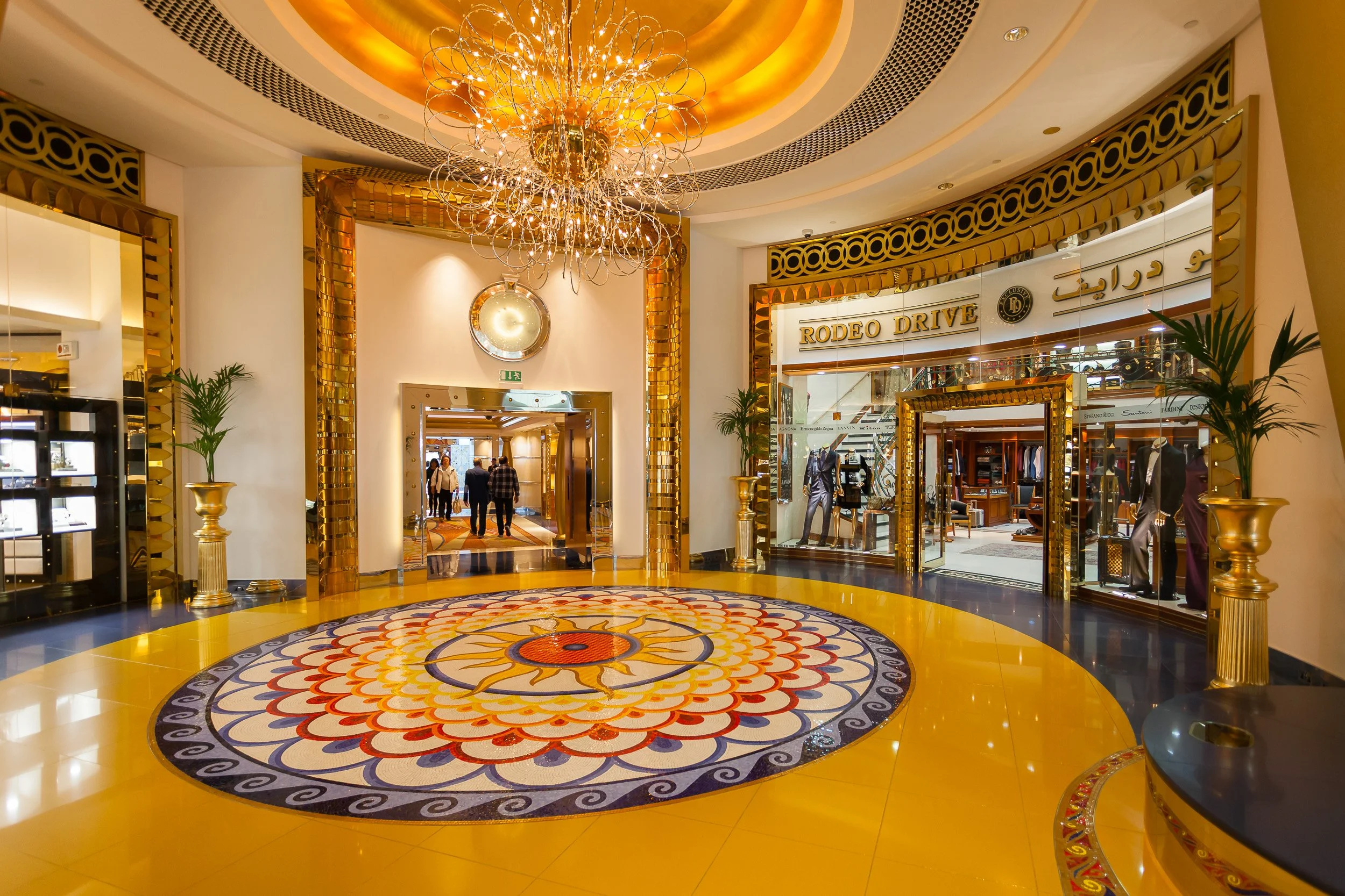 Gold, glass and chandelier light inside Burj Al Arab, capturing the theatrical luxury of one of Dubai’s most iconic interiors.