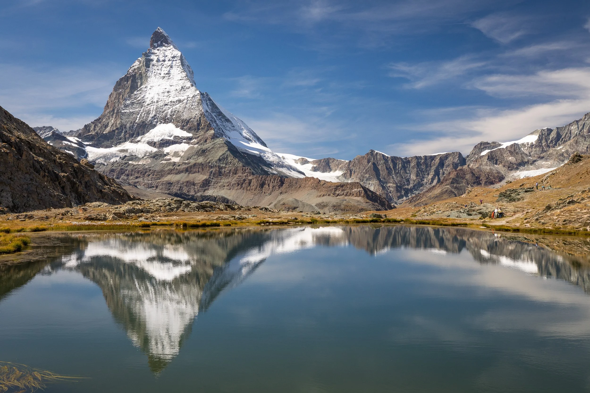 Matterhorn mirrored in the still waters of Riffelsee under a clear late-summer sky above Zermatt in the Swiss Alps.
